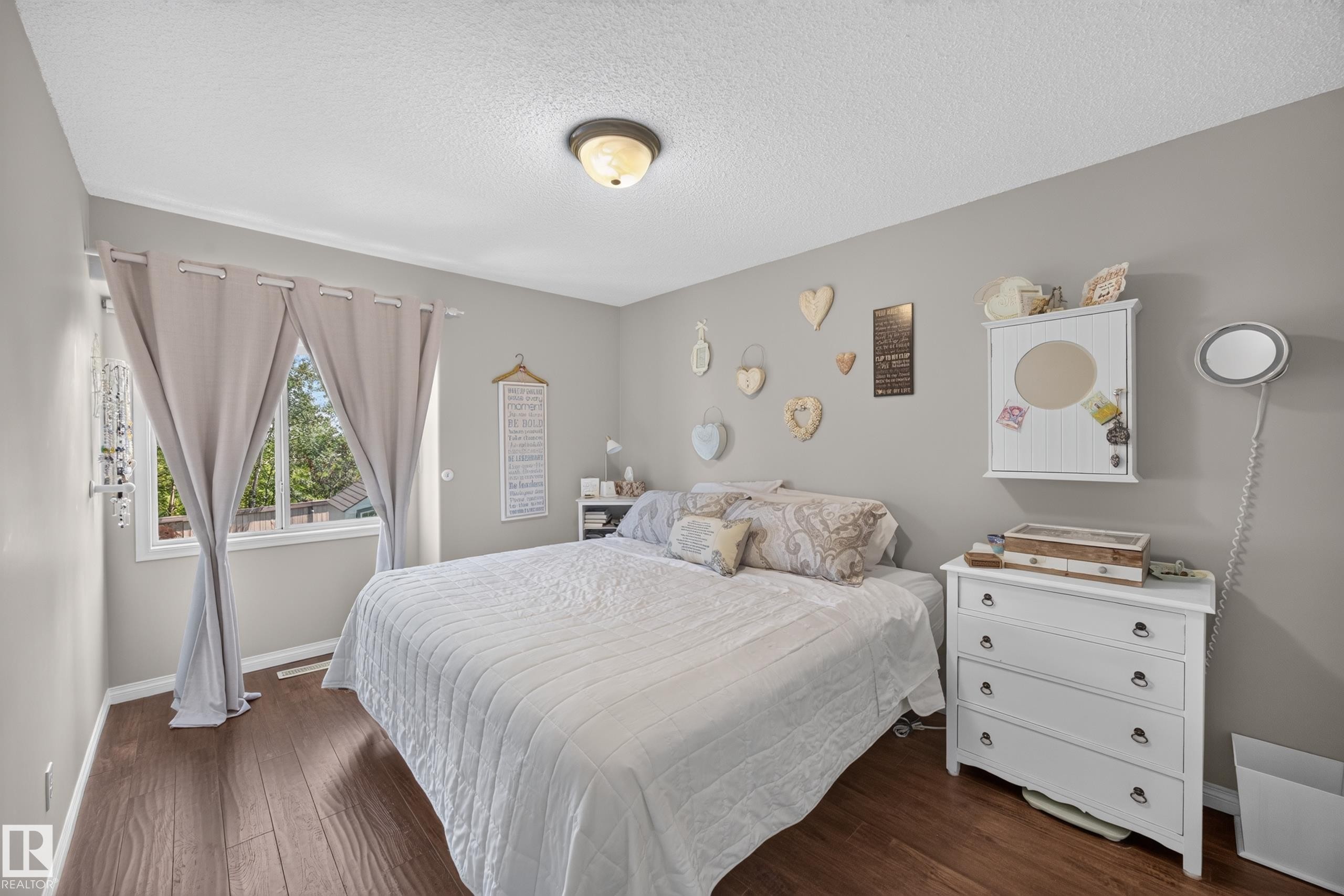 Warm wood-finish flooring complements light-toned walls - #7 155 Crocus Cr, Sherwood Park, AB - Indoor Photo Showing Bedroom