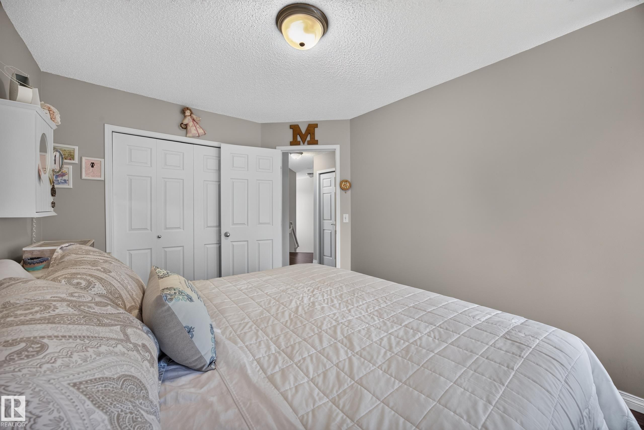 Spacious room featuring neutral painted walls, textured ceiling, and a ceiling-mounted light fixture - #7 155 Crocus Cr, Sherwood Park, AB - Indoor Photo Showing Bedroom