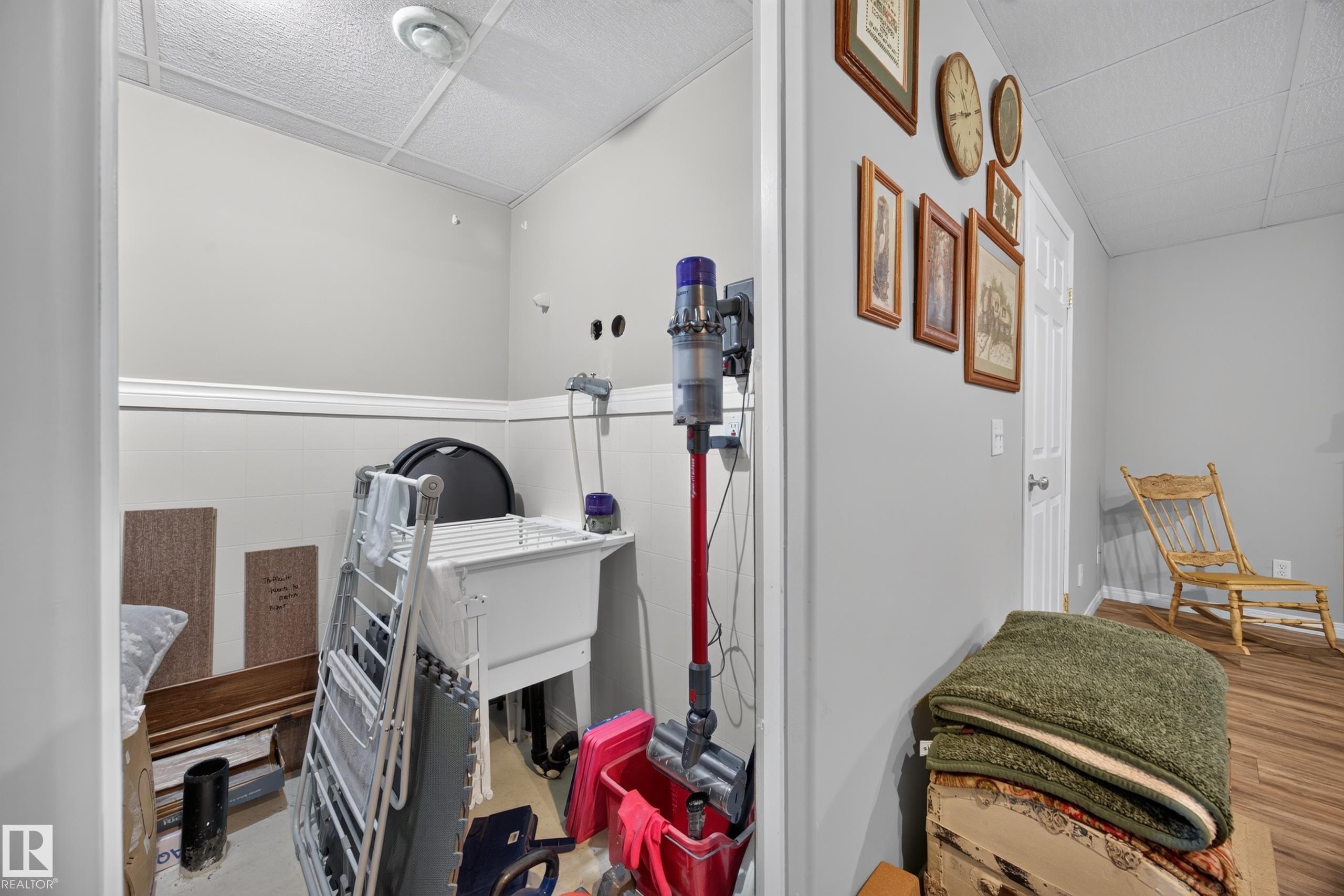 Utility room with a large basin sink, paneled walls with white trim, and a drop ceiling - #7 155 Crocus Cr, Sherwood Park, AB - Indoor Photo Showing Other Room