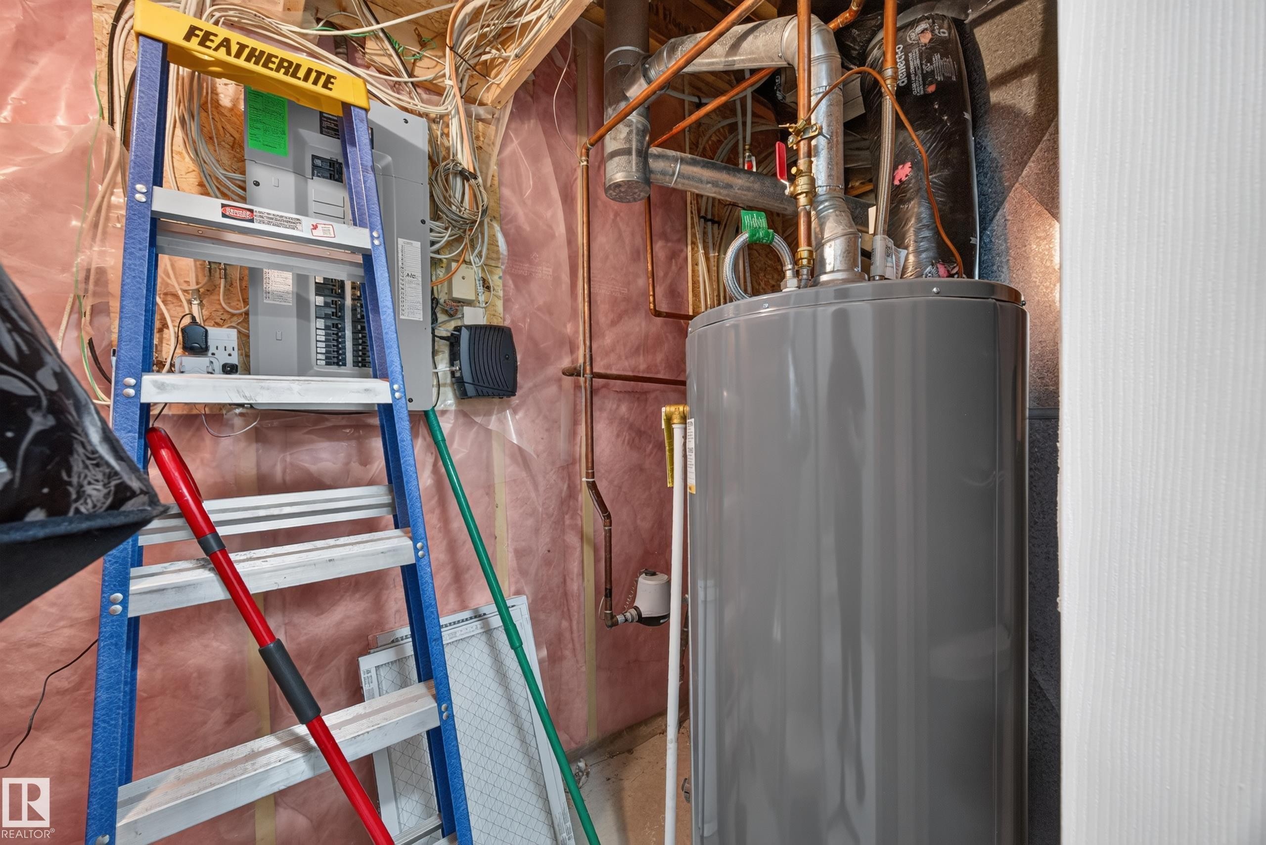 Basement utility area featuring a water heater, electrical panel, exposed copper piping, and insulation - #7 155 Crocus Cr, Sherwood Park, AB - Indoor