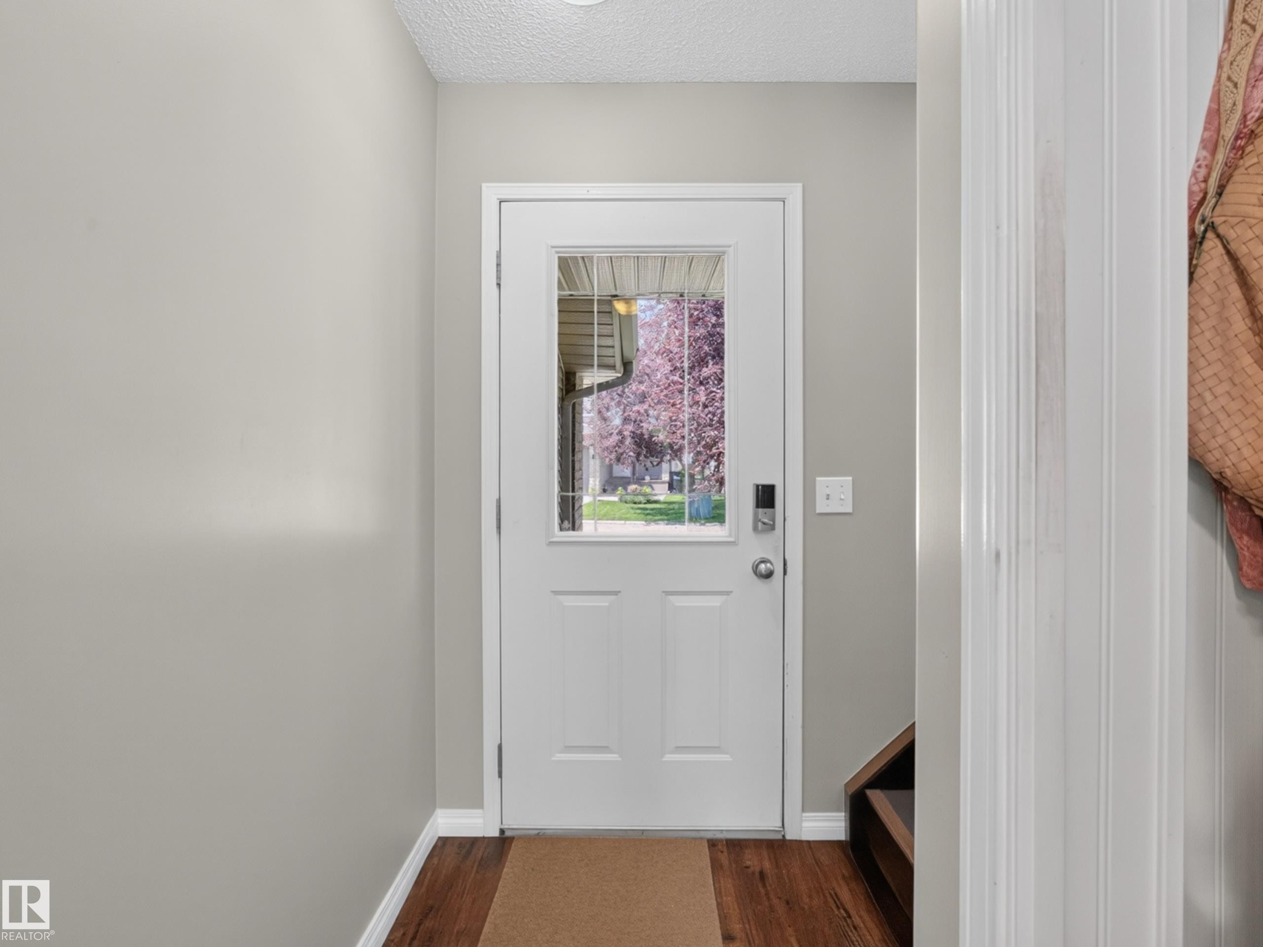 Entryway featuring wood-finish flooring and a white door with an upper glass pane - #7 155 Crocus Cr, Sherwood Park, AB - Indoor Photo Showing Other Room
