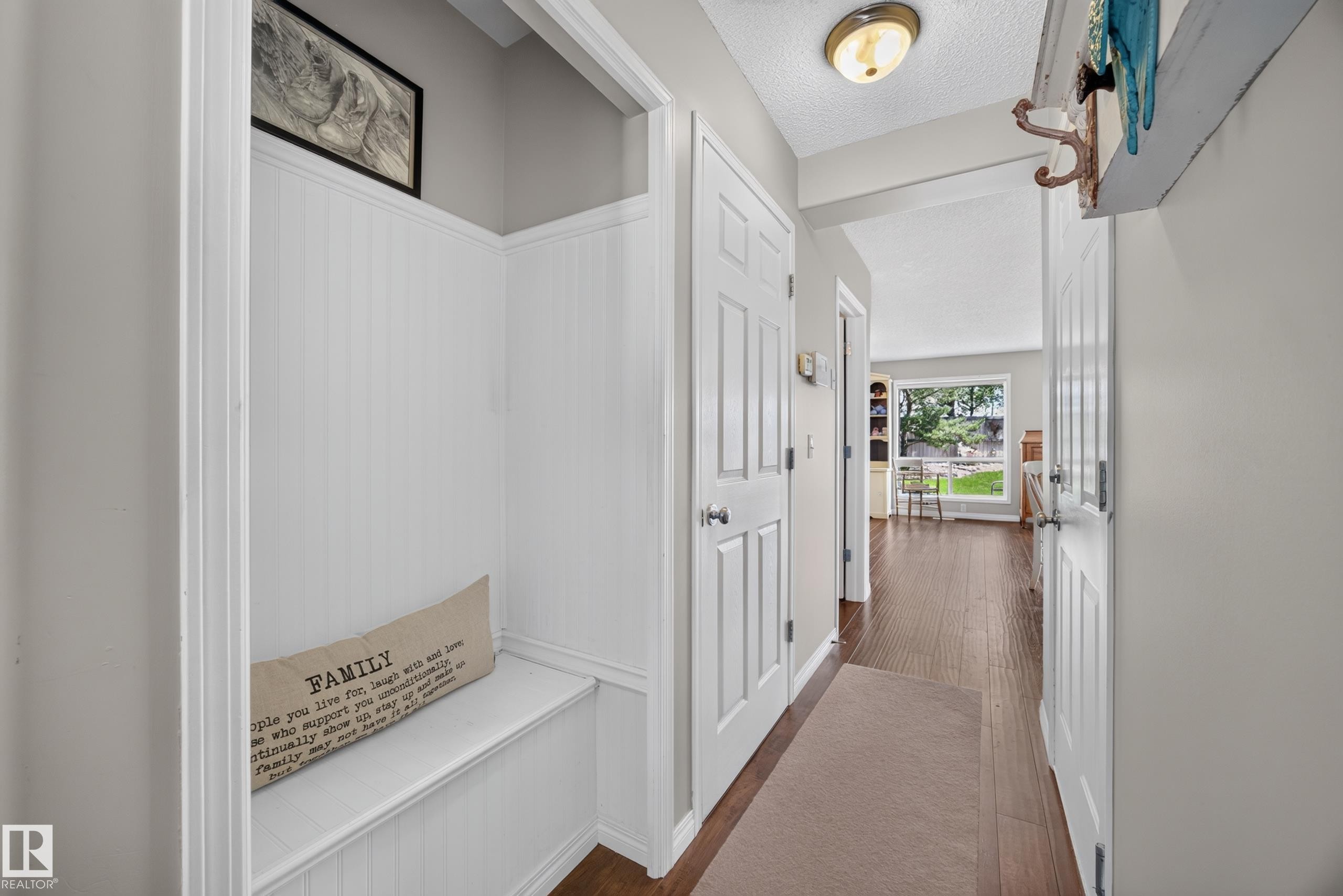 Entryway featuring a built-in bench, beadboard wainscoting, and wood-finish flooring - #7 155 Crocus Cr, Sherwood Park, AB - Indoor Photo Showing Other Room
