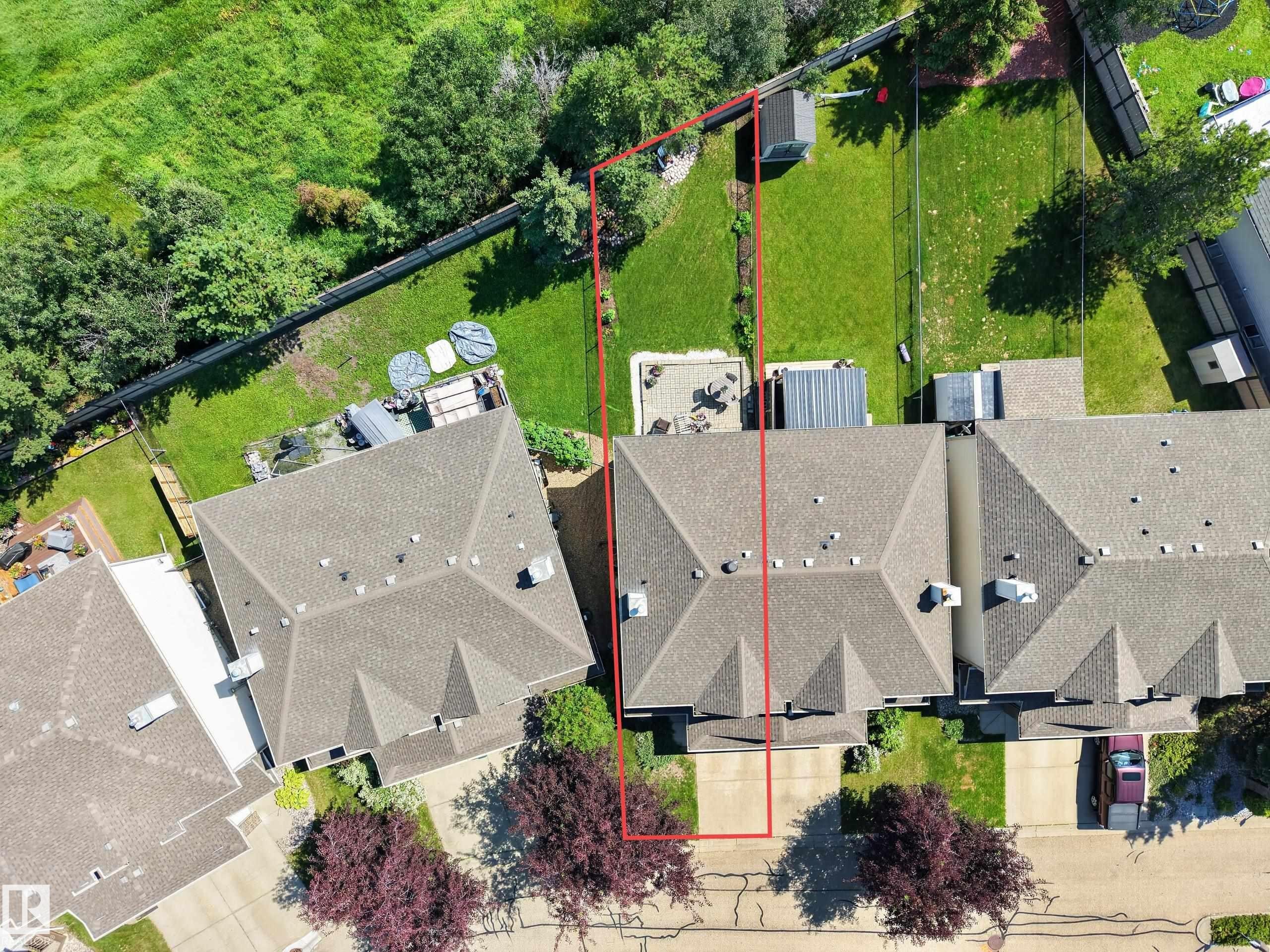 Overhead perspective showcasing a residential property with a shingled roof, a paved driveway, and a fenced backyard featuring a patio area - #7 155 Crocus Cr, Sherwood Park, AB - Outdoor With View