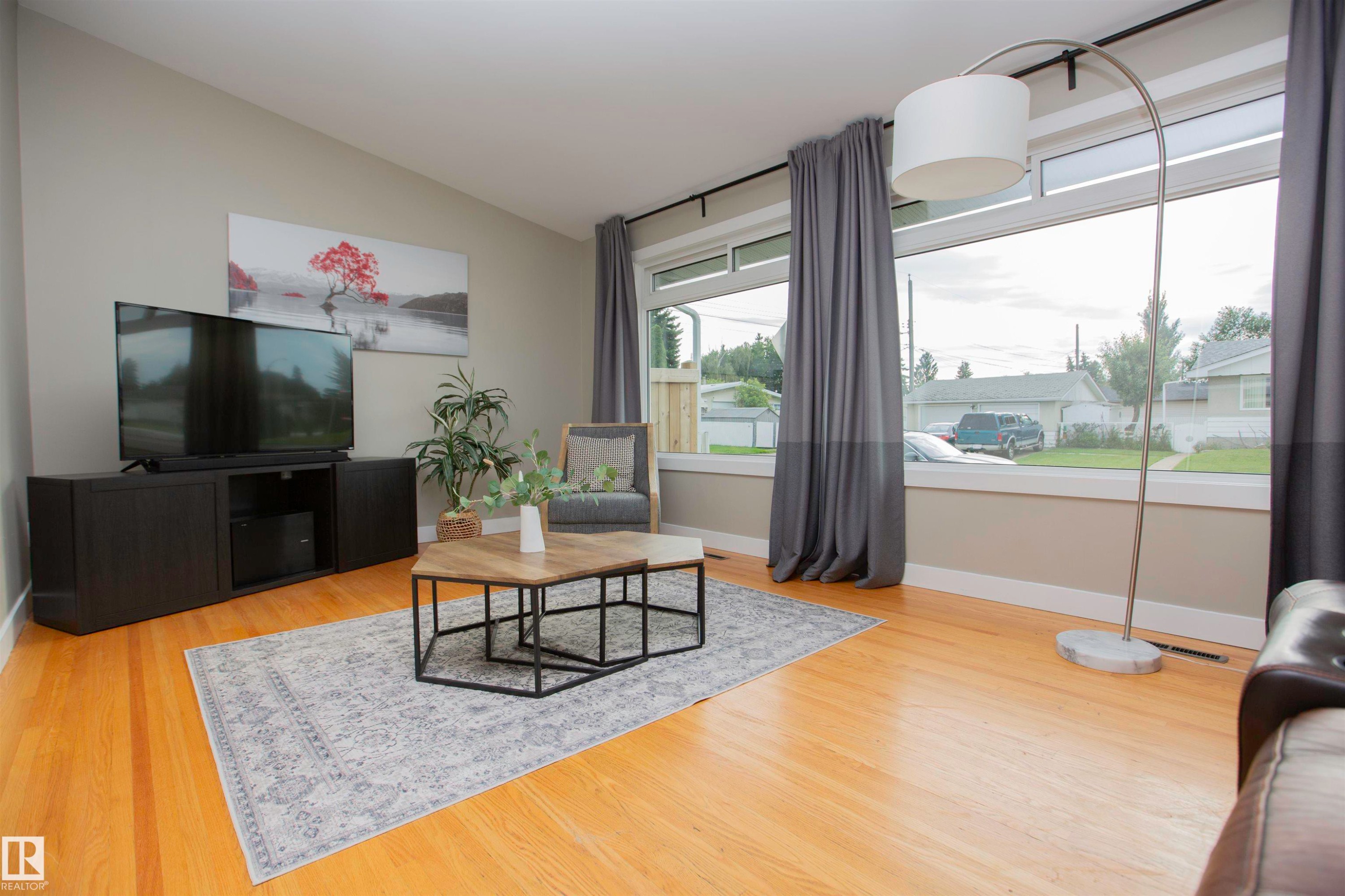 Hardwood flooring, expansive window, neutral wall paint, and recessed lighting - 9107 58 Street Nw, Edmonton, AB - Indoor Photo Showing Living Room