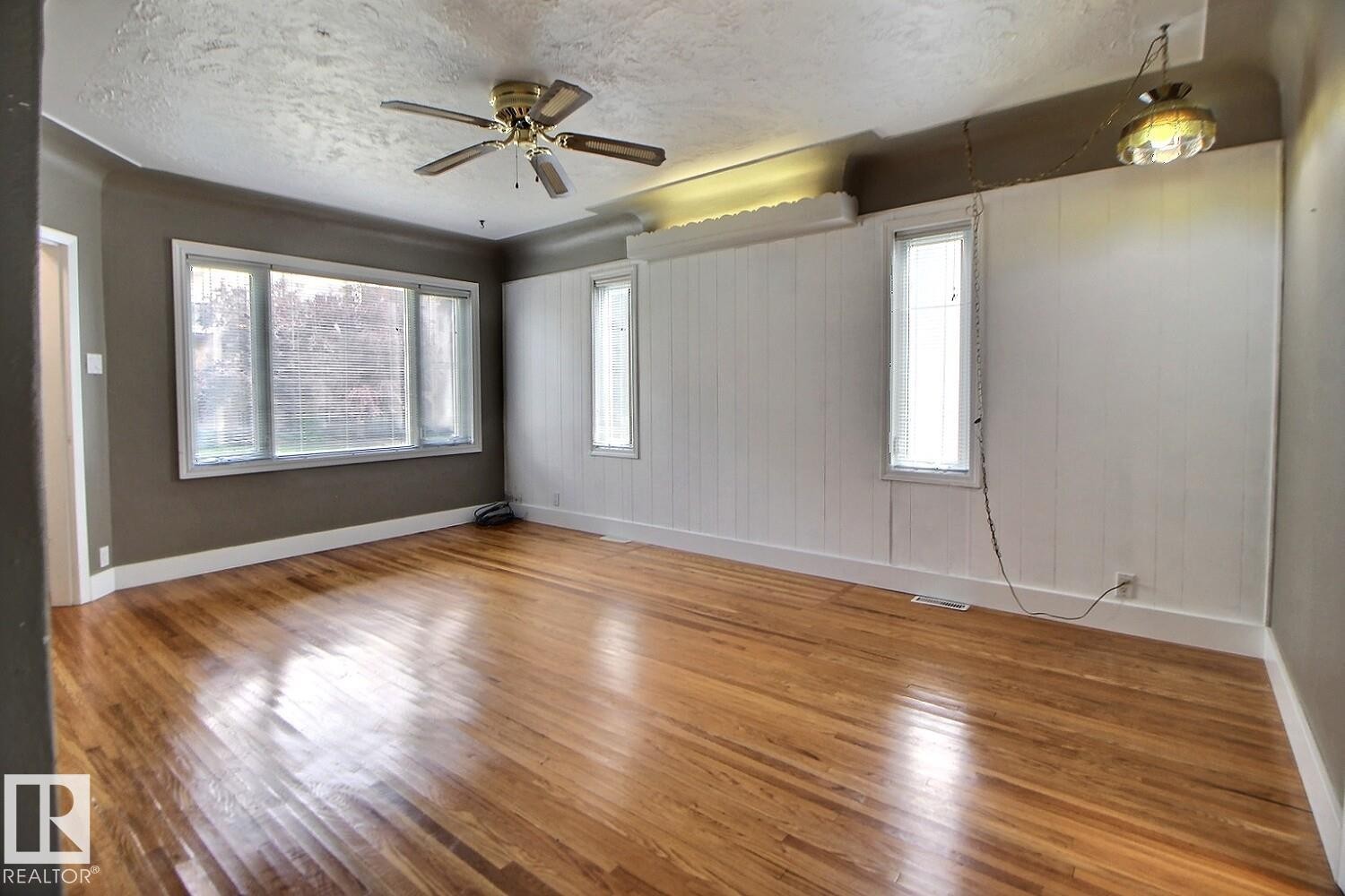 Hardwood flooring, multi-pane window, ceiling fan, wainscoting, and recessed window - 11336 83 Street Nw, Edmonton, AB - Indoor Photo Showing Other Room