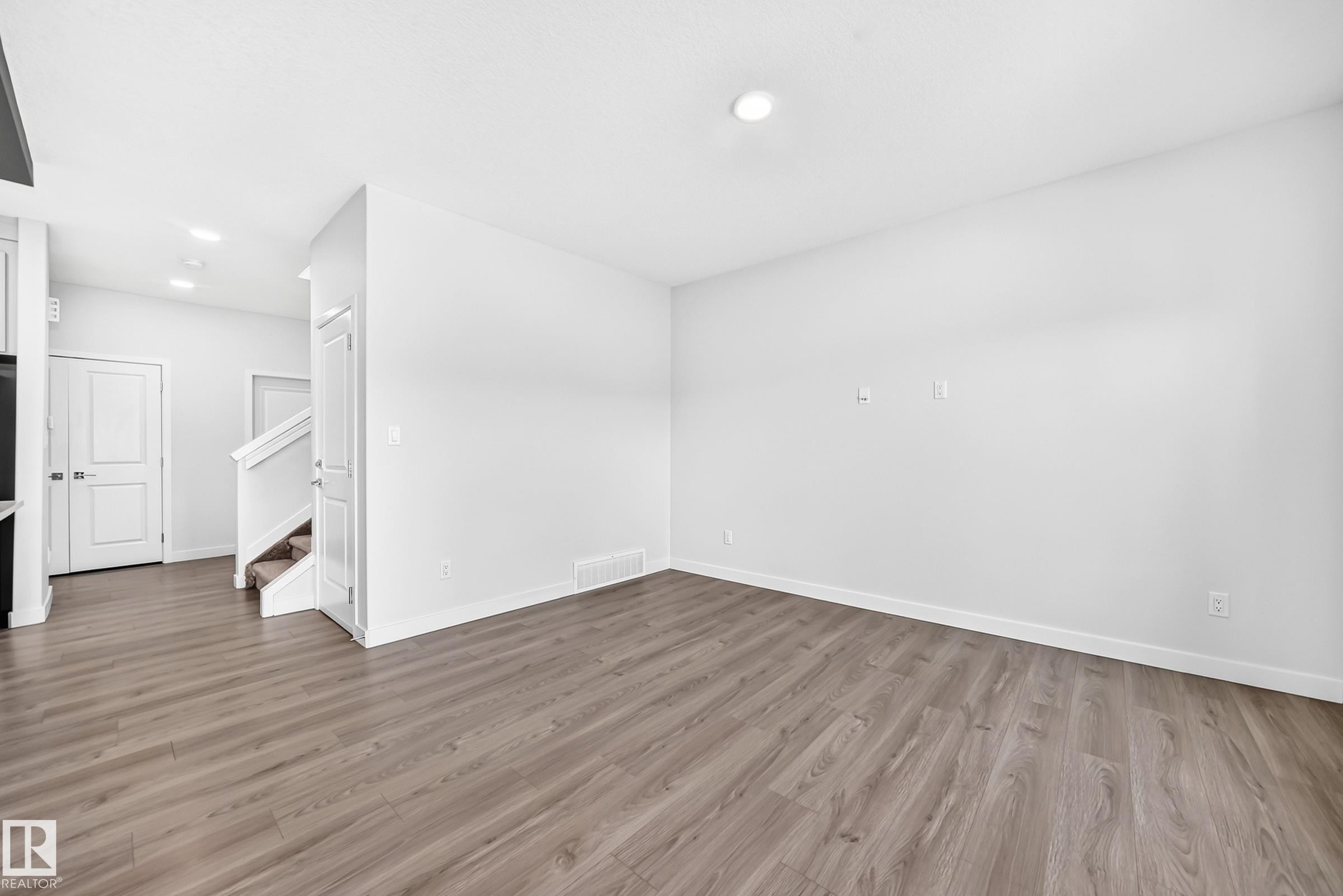 Recessed ceiling lighting, wood-finish flooring, white walls, and a staircase with carpeted treads - 8823 Carson Way Sw, Edmonton, AB - Indoor Photo Showing Other Room