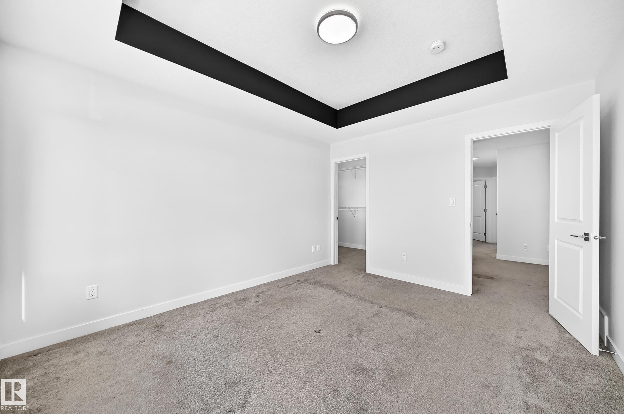 Recessed tray ceiling with black accent, flush mount ceiling light fixture, and carpet flooring - 8823 Carson Way Sw, Edmonton, AB - Indoor Photo Showing Other Room