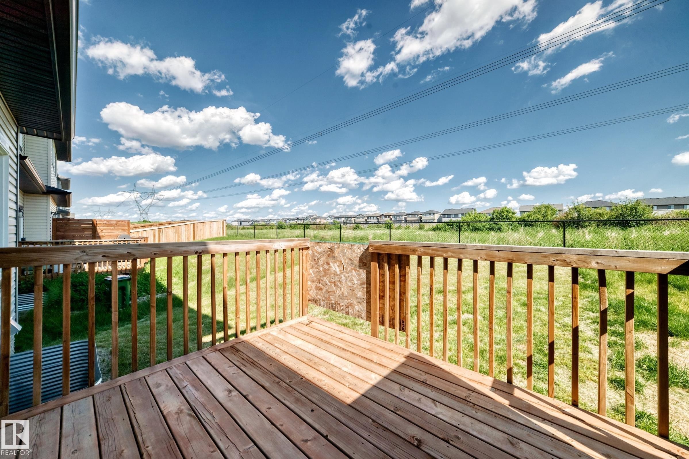 Wood-plank deck with a wood railing and a spacious grass yard - 8823 Carson Way Sw, Edmonton, AB - Outdoor With Deck Patio Veranda