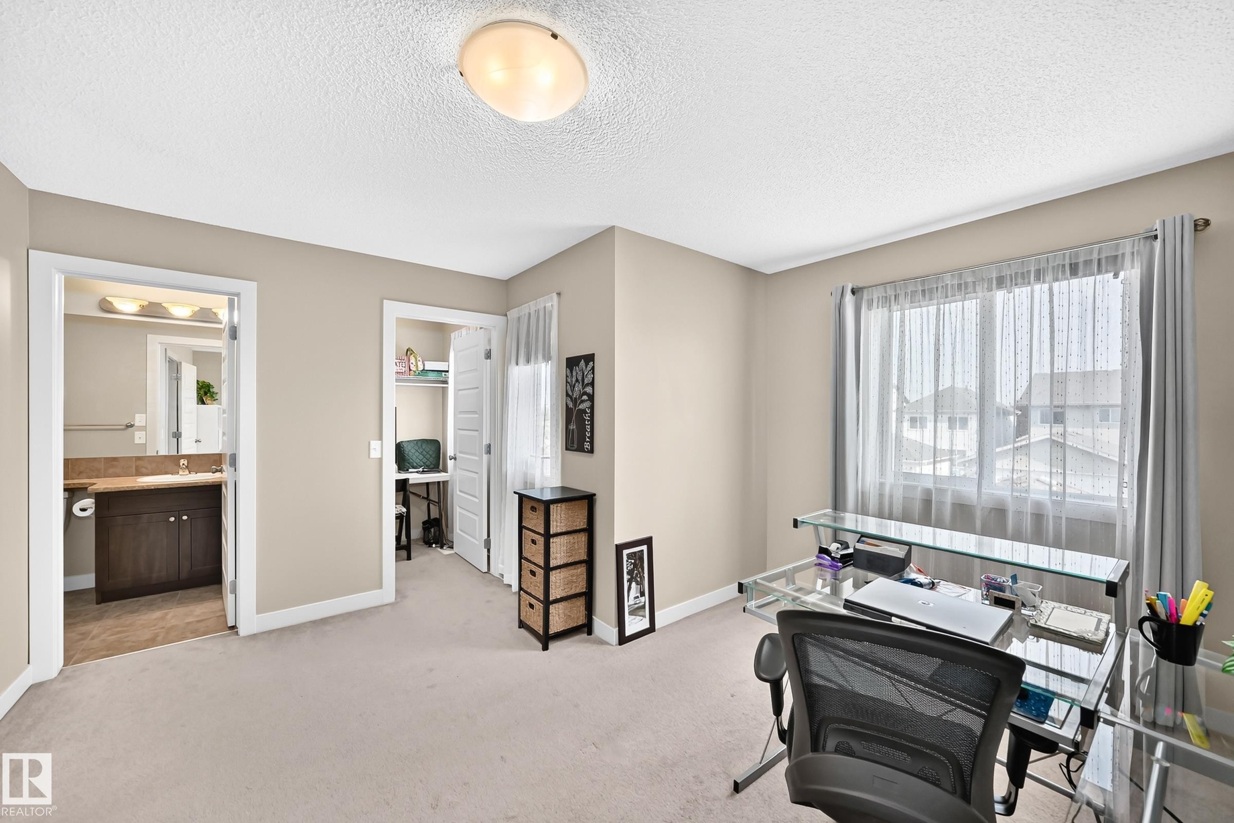 Carpeted room featuring a window with sheer and blackout curtains, a ceiling-mounted light fixture, and neutral wall tones - 466 Chappelle Drive Sw, Edmonton, AB - Indoor