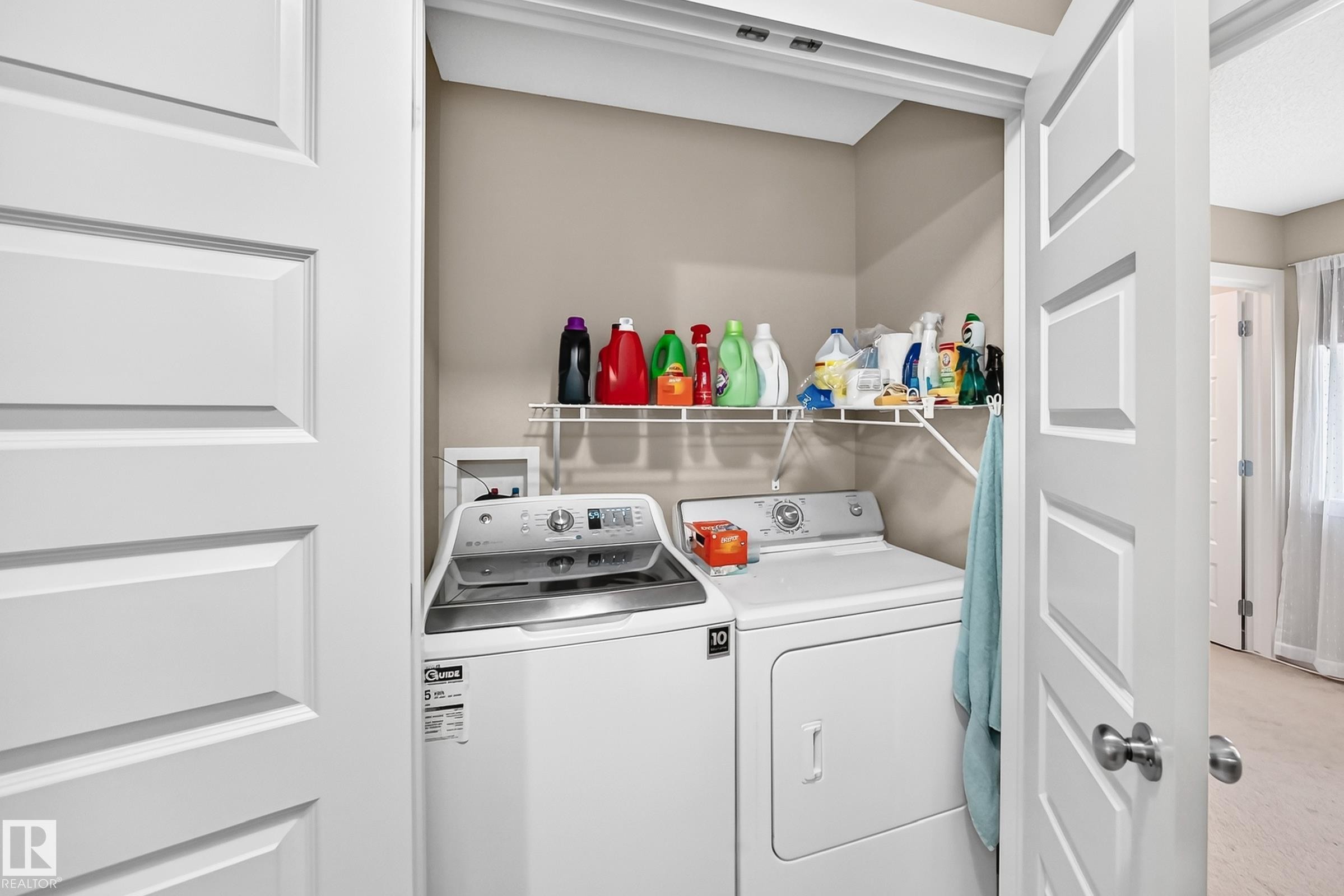 Laundry closet featuring bi-fold panel doors, upper wire shelving, and neutral wall paint - 466 Chappelle Drive Sw, Edmonton, AB - Indoor Photo Showing Laundry Room