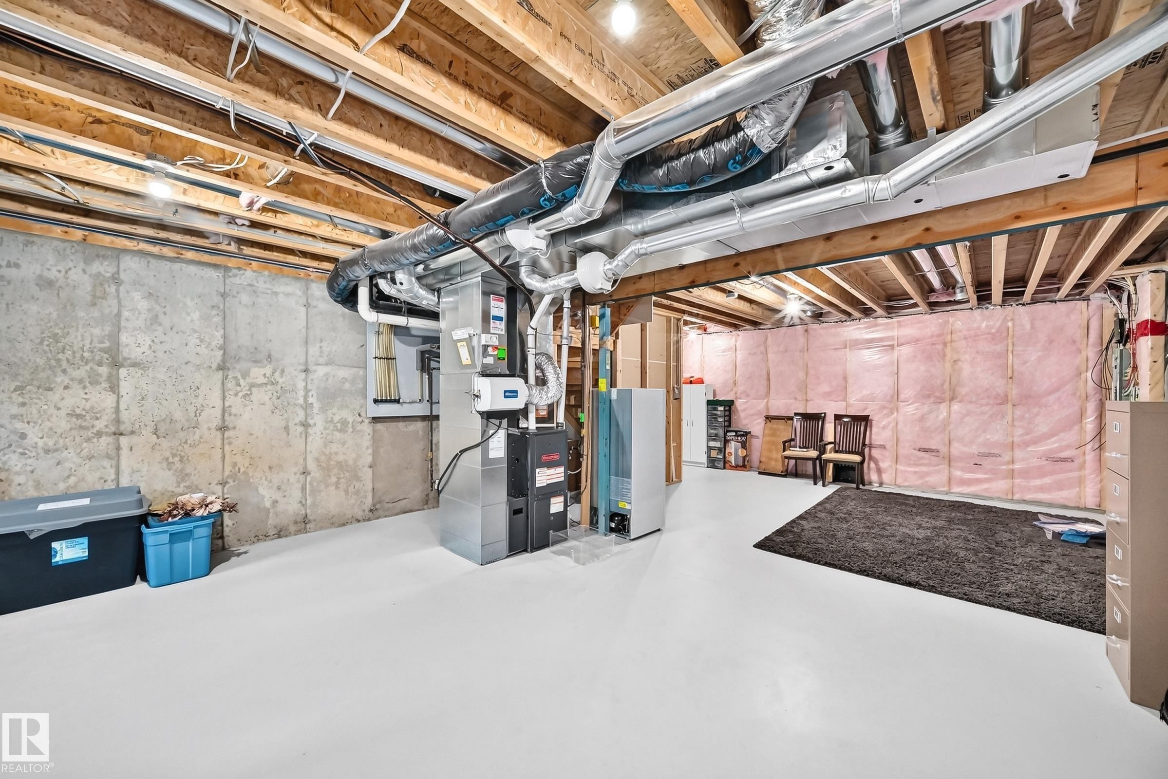 Unfinished basement featuring exposed wood joists, concrete foundation walls, and painted concrete flooring - 466 Chappelle Drive Sw, Edmonton, AB - Indoor Photo Showing Basement