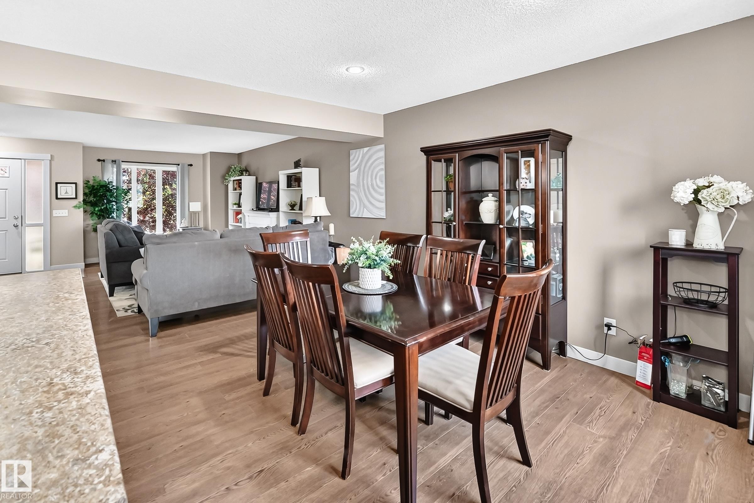 Dining area featuring wood-finish flooring, a contemporary ceiling light fixture, and a built-in display cabinet - 466 Chappelle Drive Sw, Edmonton, AB - Indoor Photo Showing Dining Room