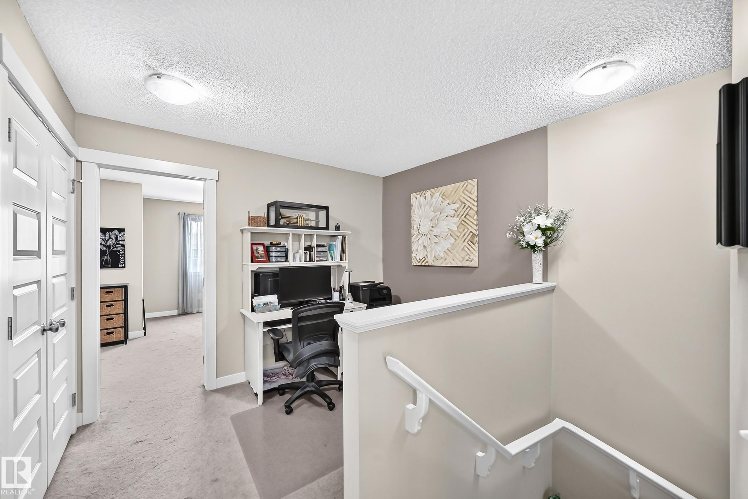 Upper-level landing featuring a built-in desk with shelving, neutral wall tones, and recessed lighting - 466 Chappelle Drive Sw, Edmonton, AB - Indoor