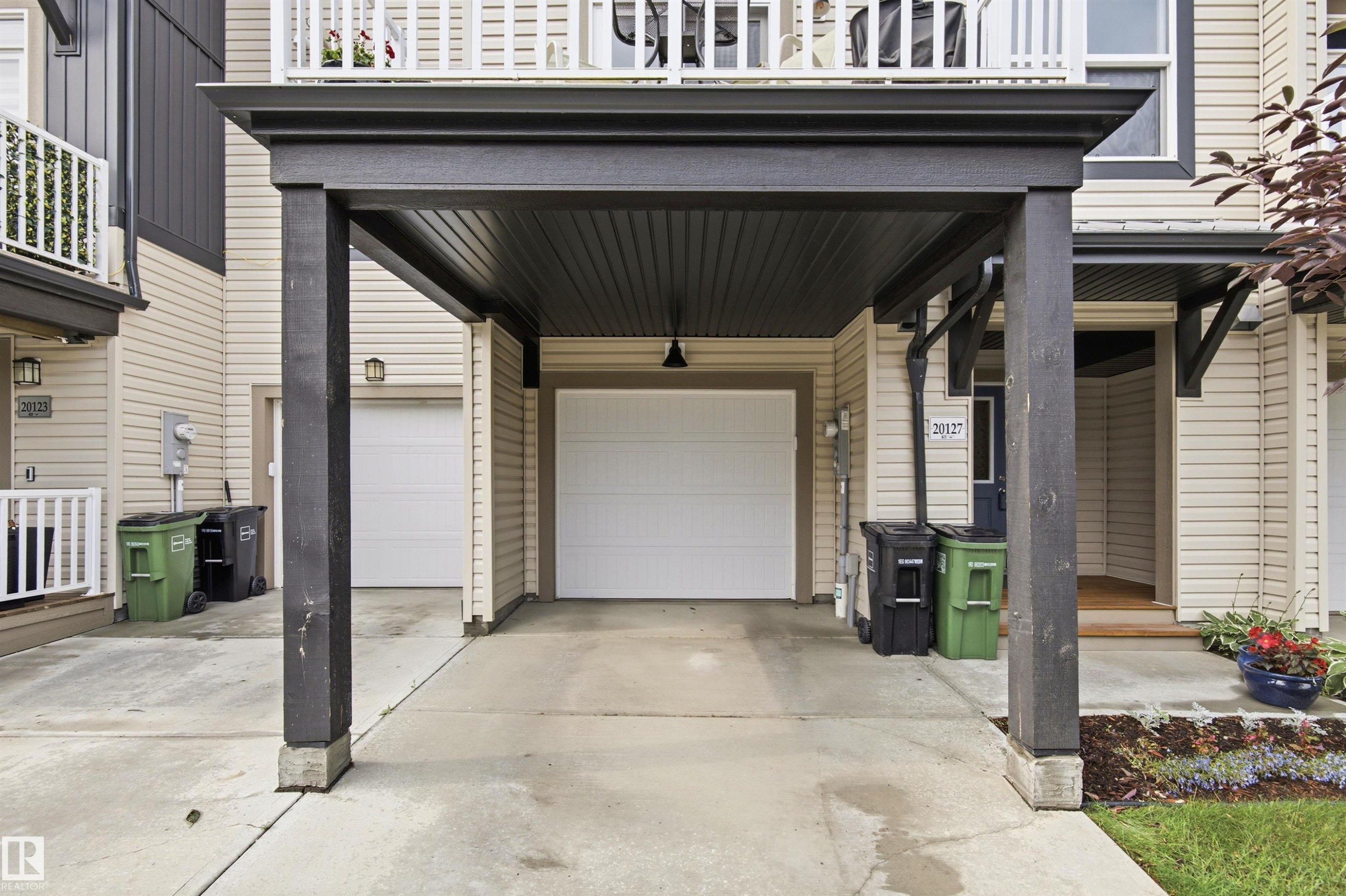 Covered carport featuring dark wood-finish support beams and a paneled ceiling - 20127 19 Avenue Nw, Edmonton, AB - Outdoor With Exterior