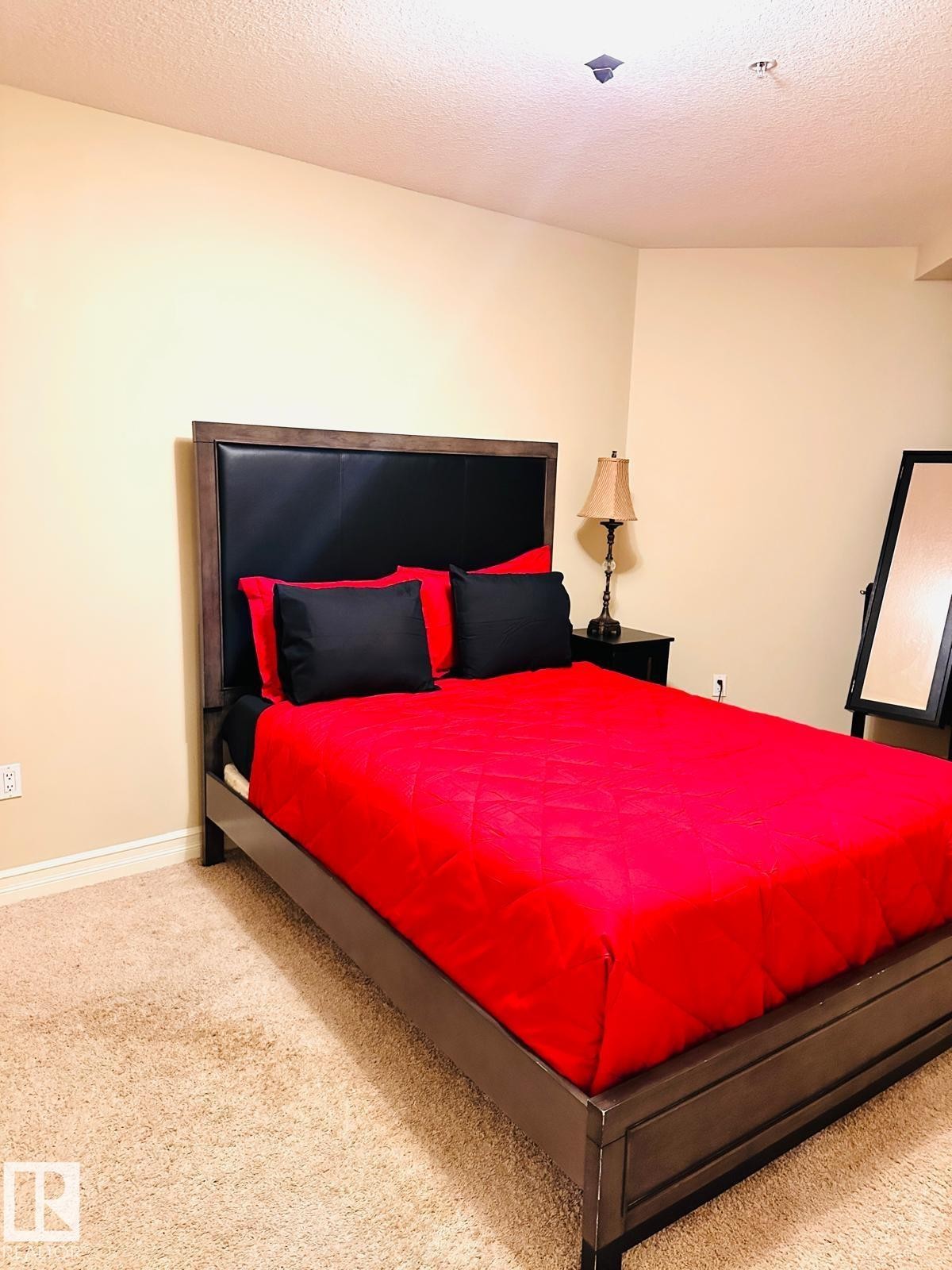 Neutral tone wall finish with a built-in recessed ceiling light and wall outlet - #207 10142 111 St Nw, Edmonton, AB - Indoor Photo Showing Bedroom