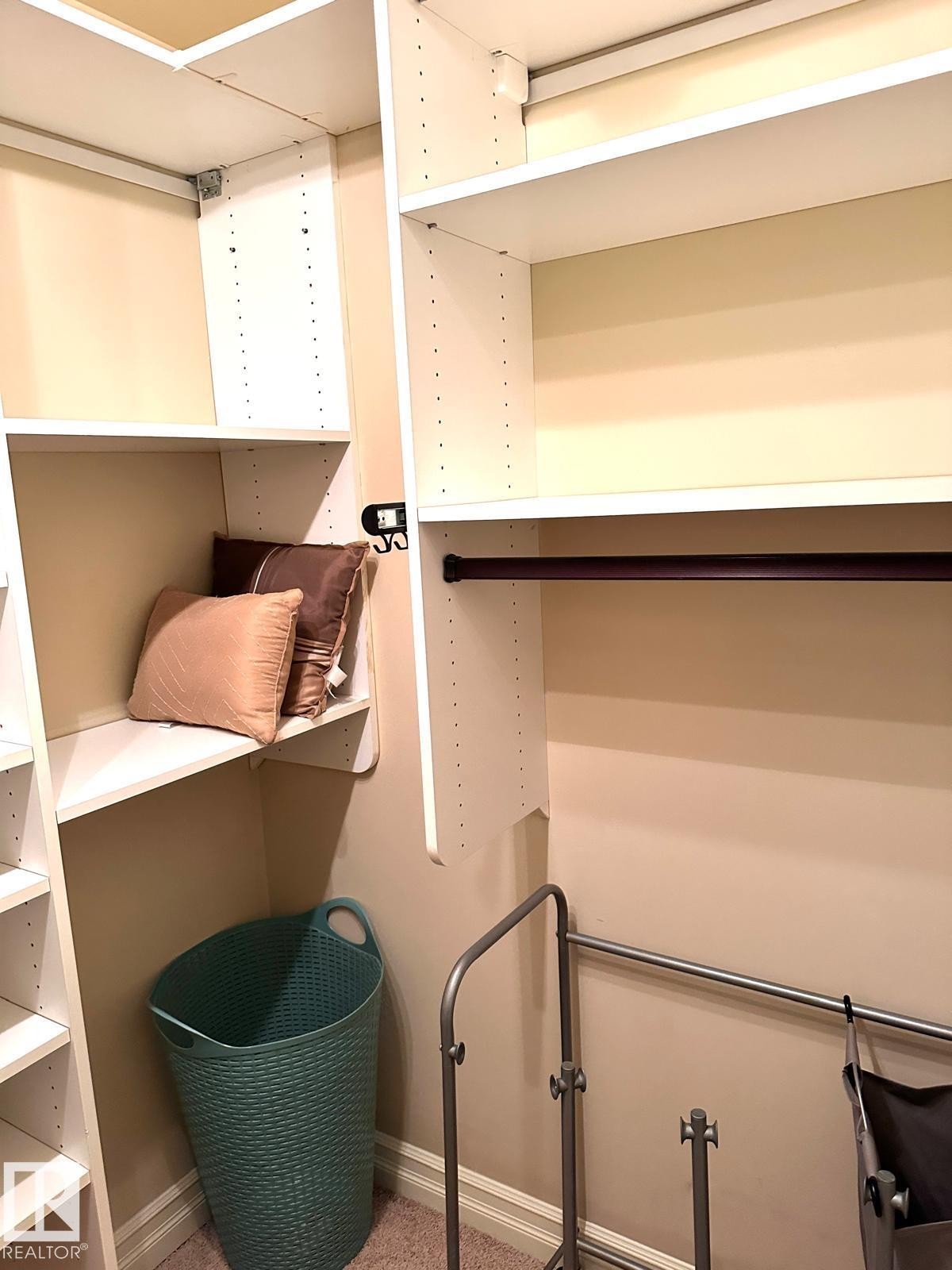 Built-in white shelving system with adjustable shelves and integrated hanging rods - #207 10142 111 St Nw, Edmonton, AB - Indoor