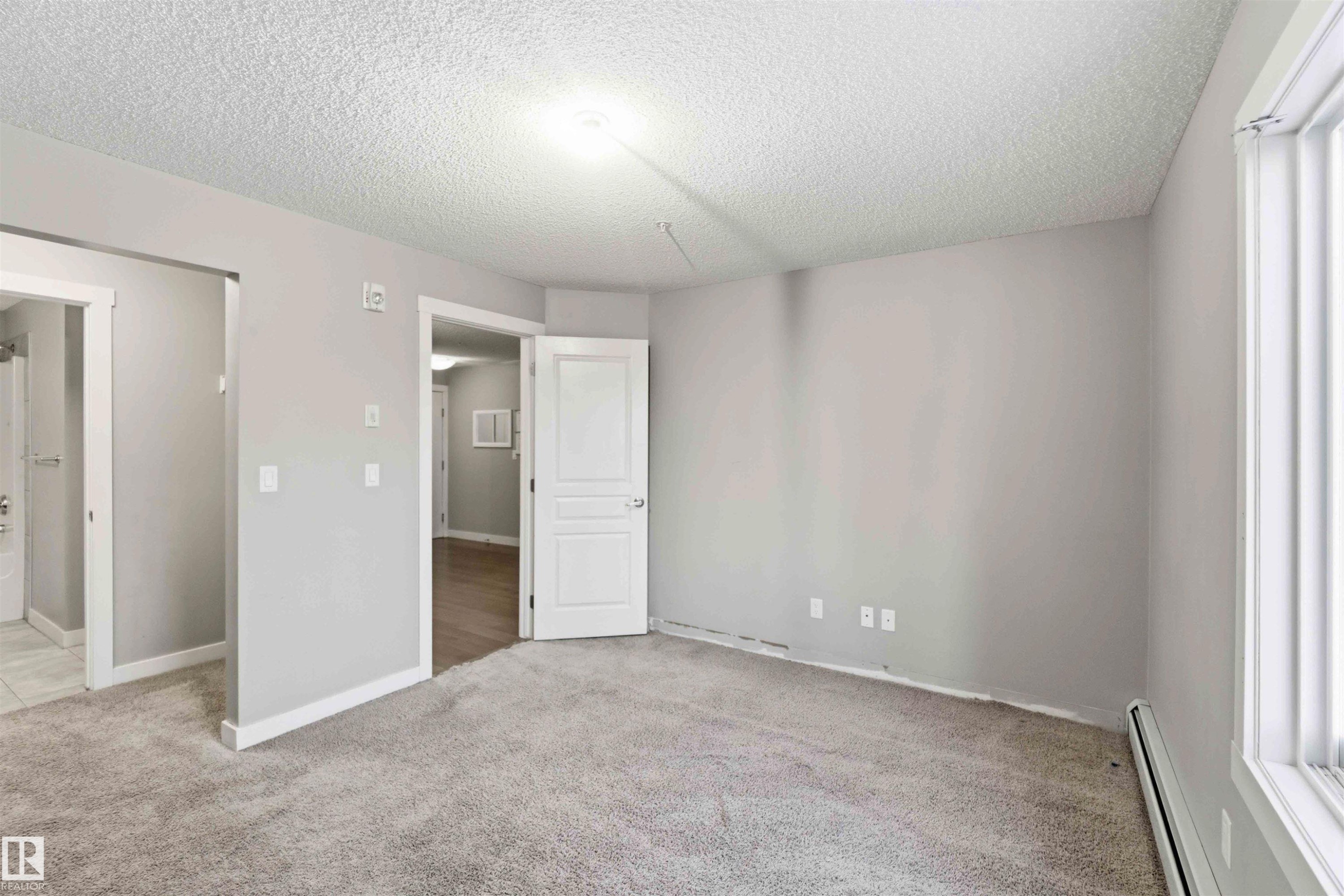 Carpeted room with light gray walls, white trim, and a window with horizontal blinds - #114 2207 44 Av Nw, Edmonton, AB - Indoor Photo Showing Other Room