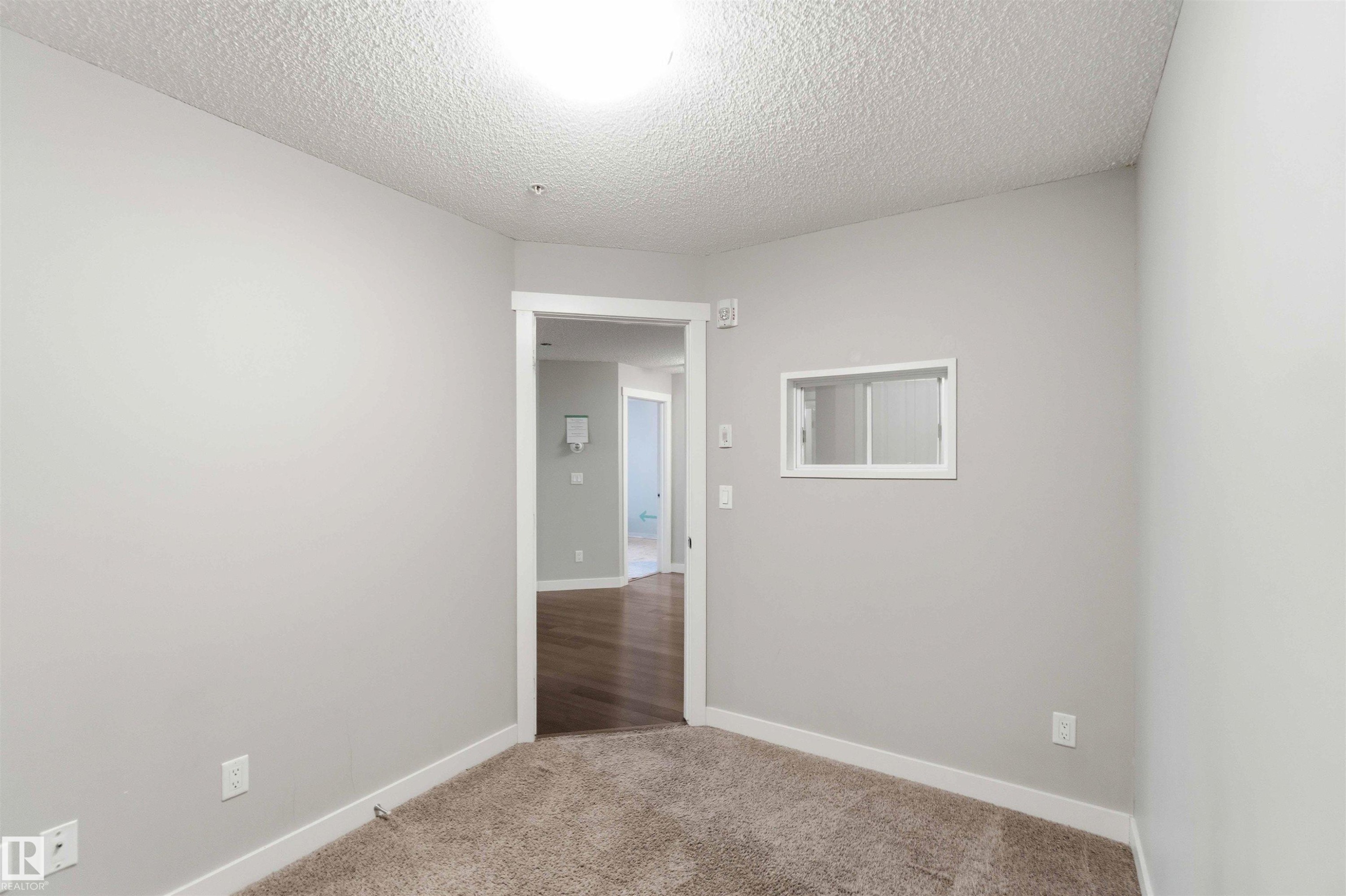 Carpeted room featuring light gray walls and white trim - #114 2207 44 Av Nw, Edmonton, AB - Indoor Photo Showing Other Room
