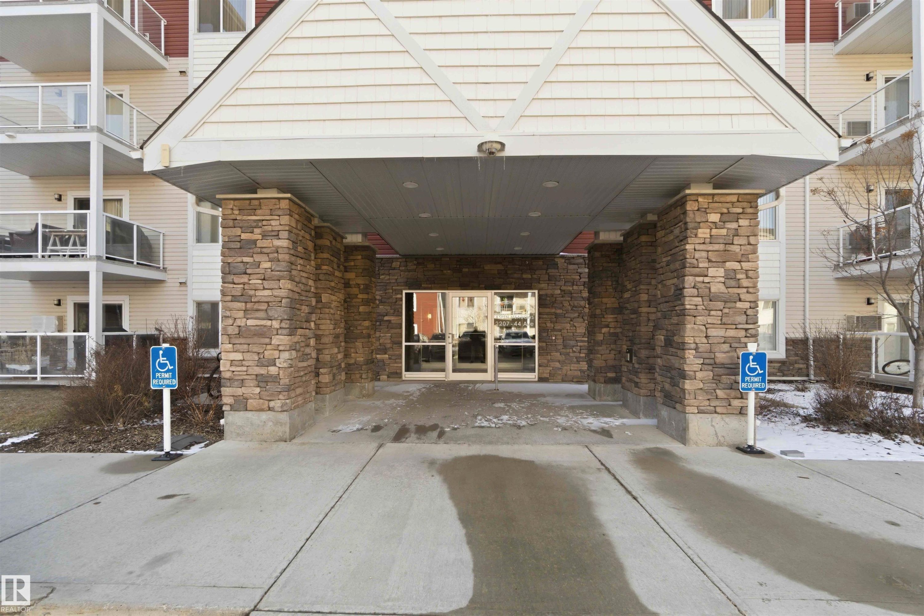 Building exterior featuring a stone-clad entrance with a covered portico - #114 2207 44 Av Nw, Edmonton, AB - Outdoor