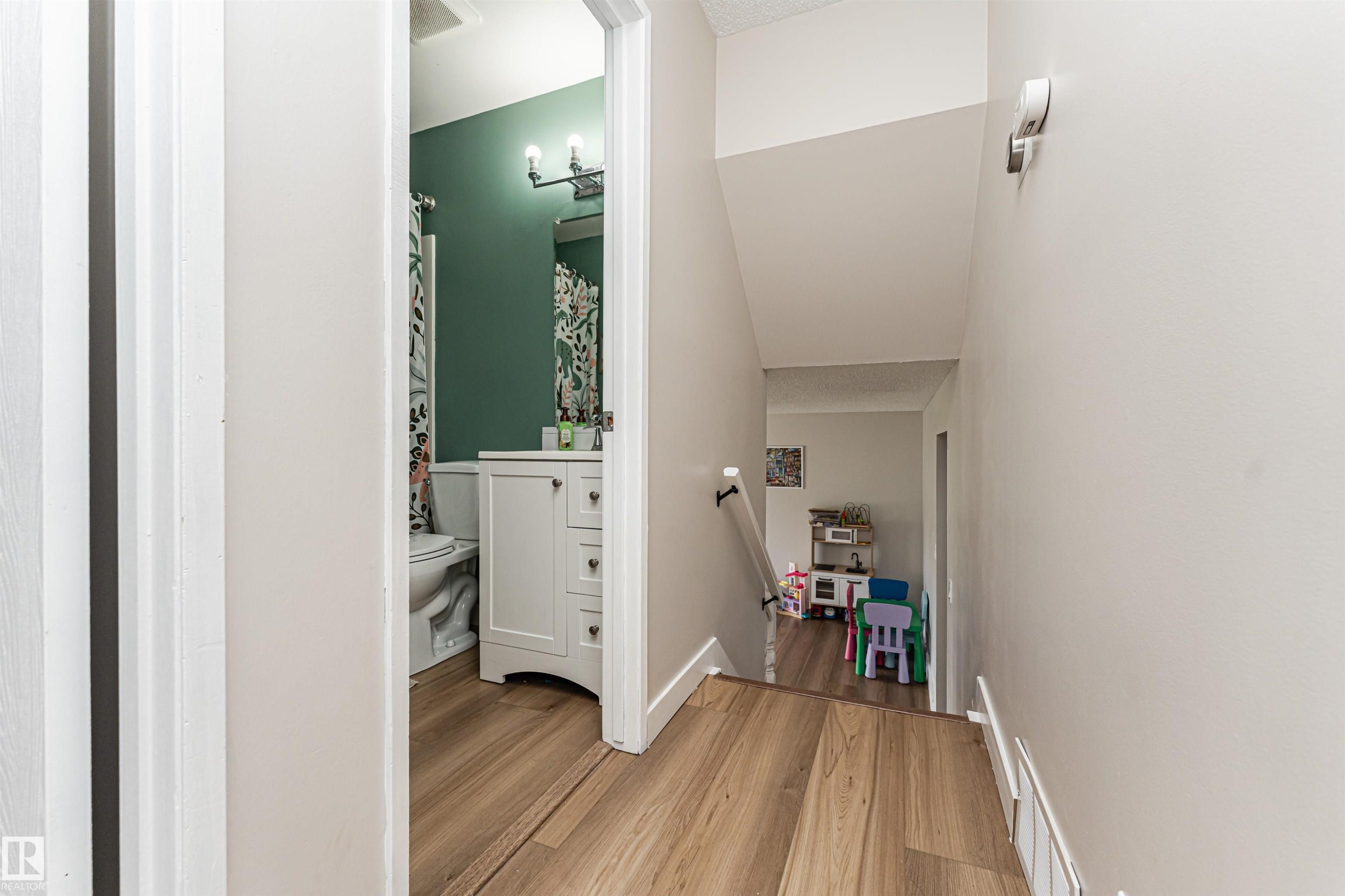 Wood-finish flooring throughout the hallway and bathroom - 4521 29 Avenue Nw, Edmonton, AB - Indoor Photo Showing Other Room