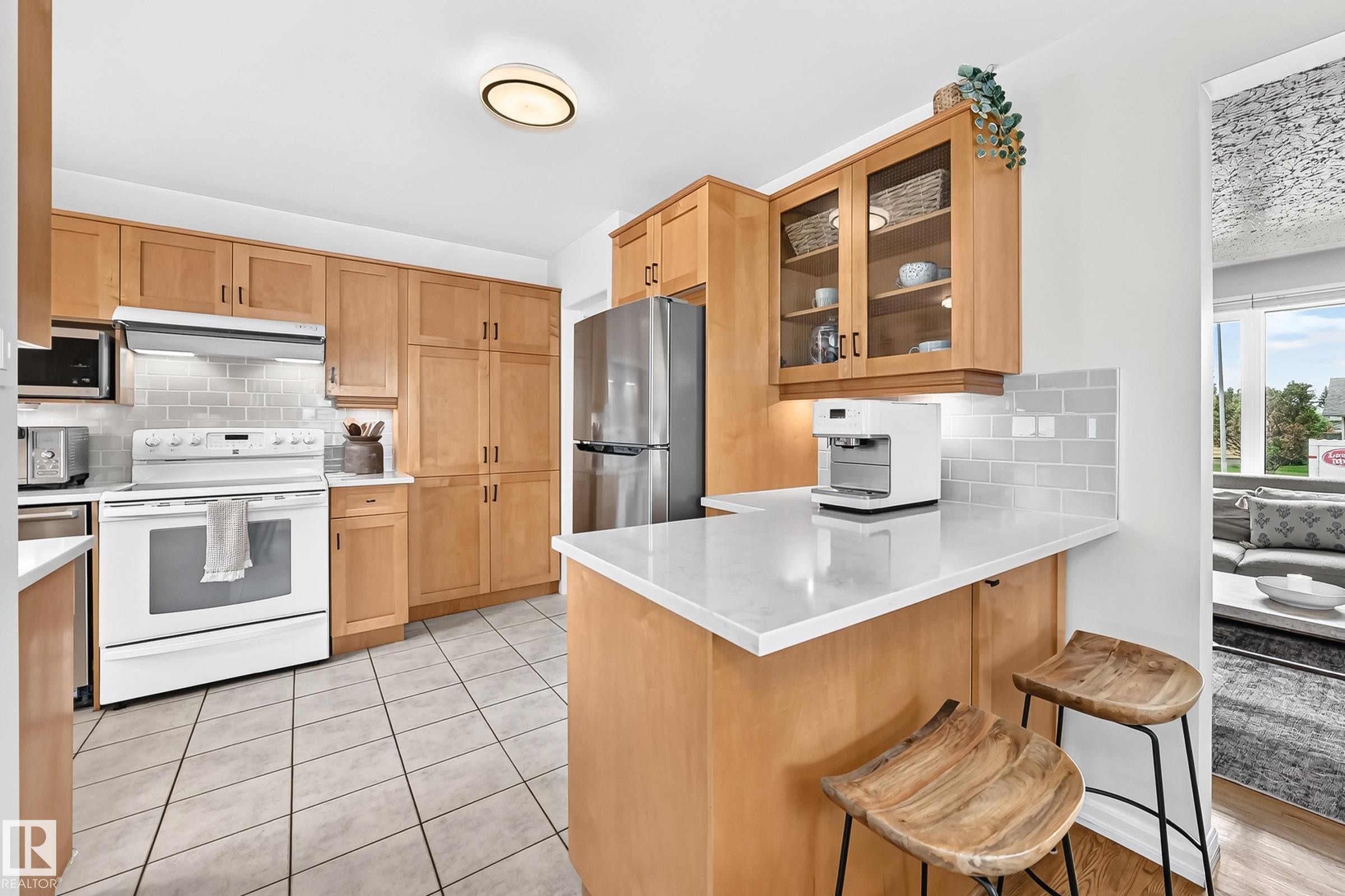Light wood cabinetry with glass-front display cabinets, white countertops, tile flooring, and a subway tile backsplash - 16406 87A Avenue Nw, Edmonton, AB - Indoor Photo Showing Kitchen