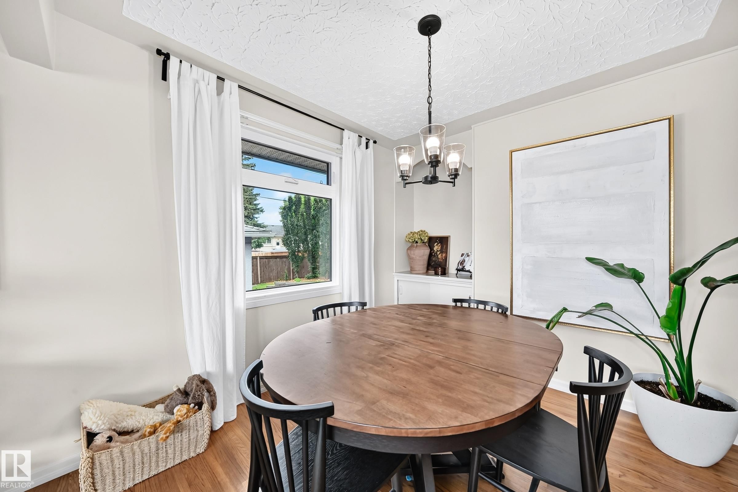 Recessed wall niche, wood-finish flooring, and a modern chandelier - 16406 87A Avenue Nw, Edmonton, AB - Indoor Photo Showing Dining Room