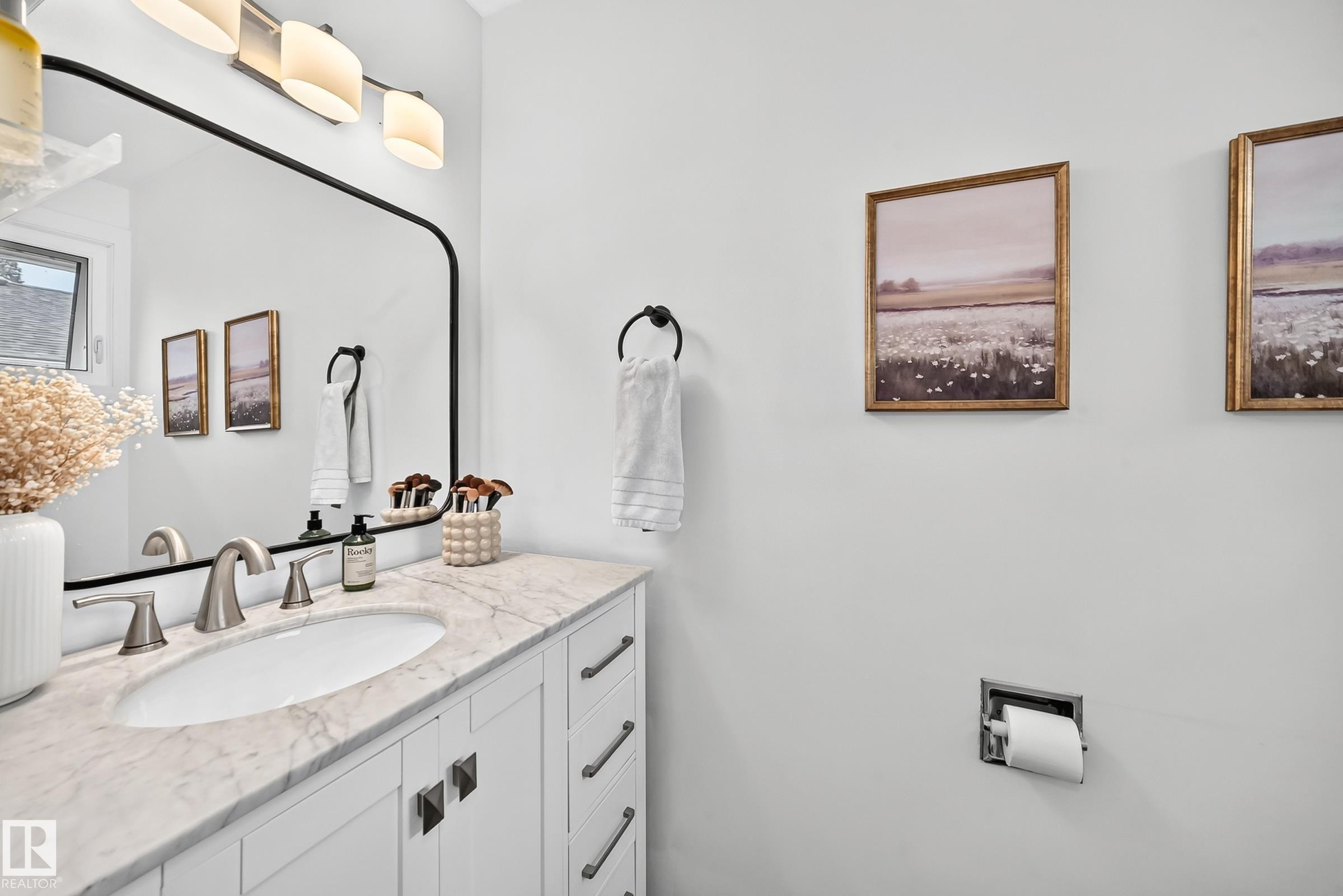 White vanity with brushed nickel hardware, oval undermount sink, marble-finish countertop, and wall-mounted vanity light - 16406 87A Avenue Nw, Edmonton, AB - Indoor Photo Showing Bathroom