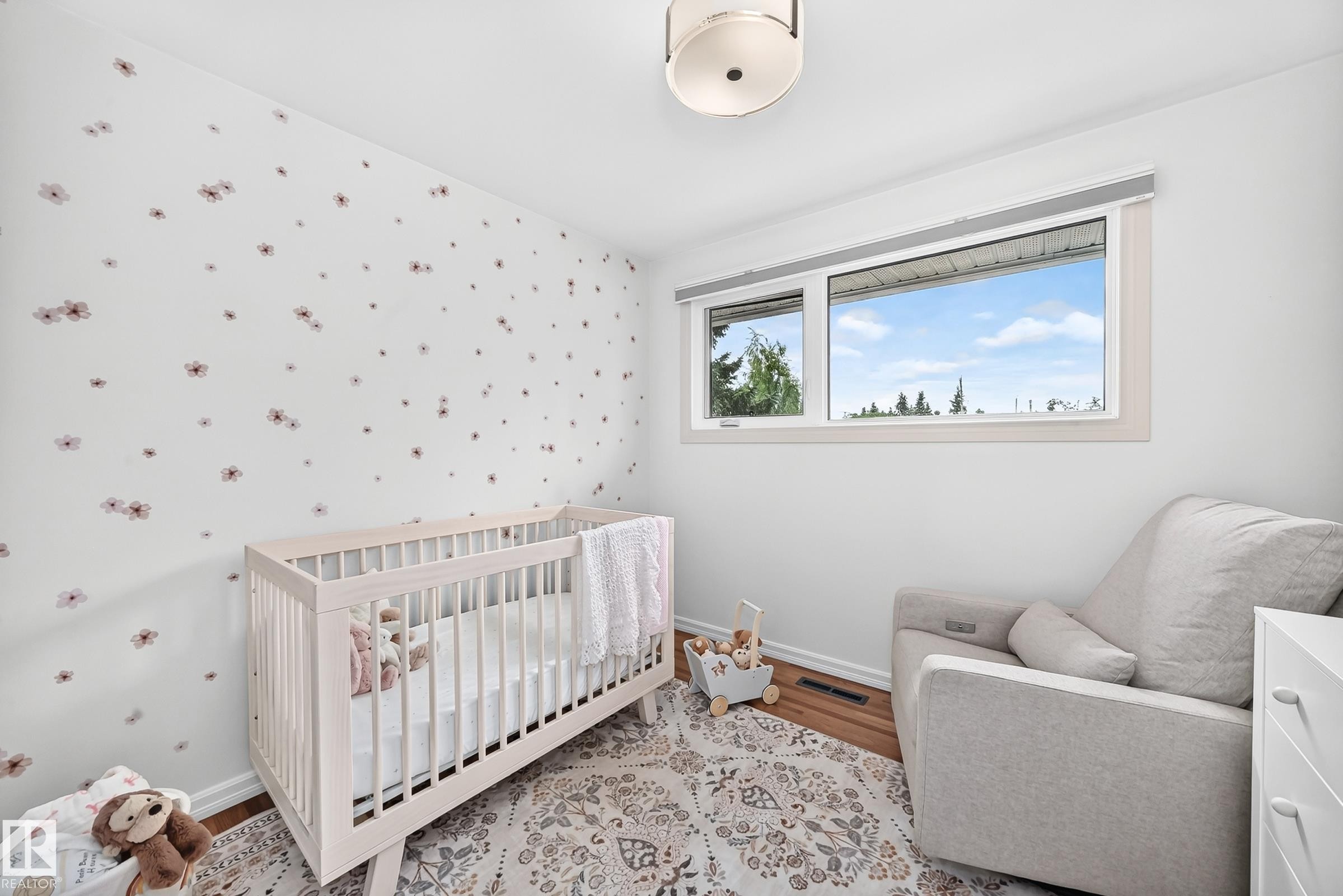 Bright room featuring a large window, a decorative wall, a flush-mount ceiling light, and wood-finish flooring - 16406 87A Avenue Nw, Edmonton, AB - Indoor Photo Showing Bedroom