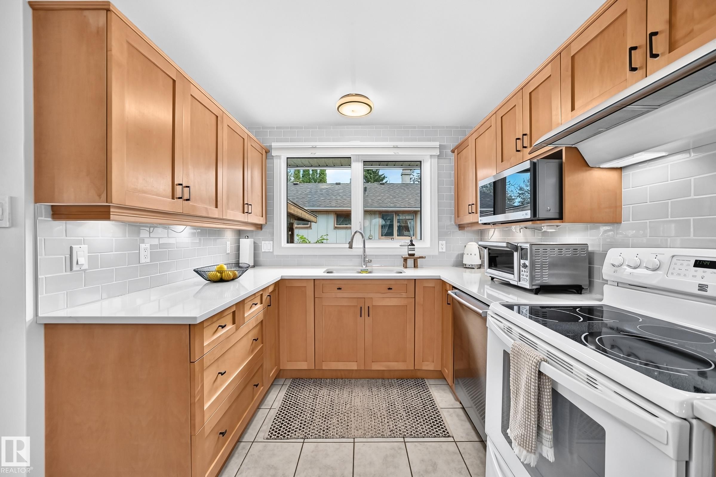 U-shaped kitchen featuring light wood cabinetry, white countertops, and a subway tile backsplash - 16406 87A Avenue Nw, Edmonton, AB - Indoor Photo Showing Kitchen