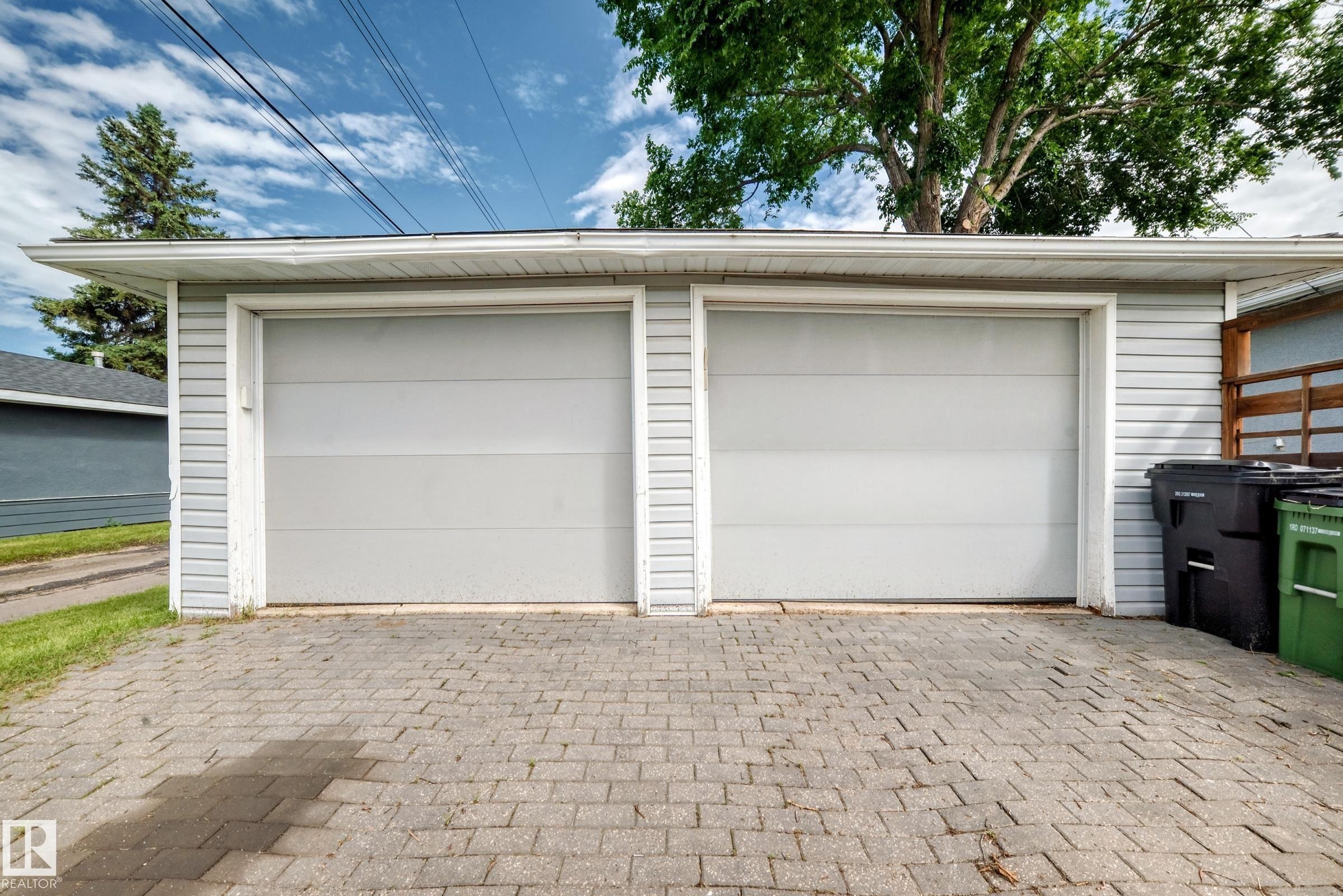 Two-car garage with light gray siding and a paver driveway - 16406 87A Avenue Nw, Edmonton, AB - Outdoor With Exterior