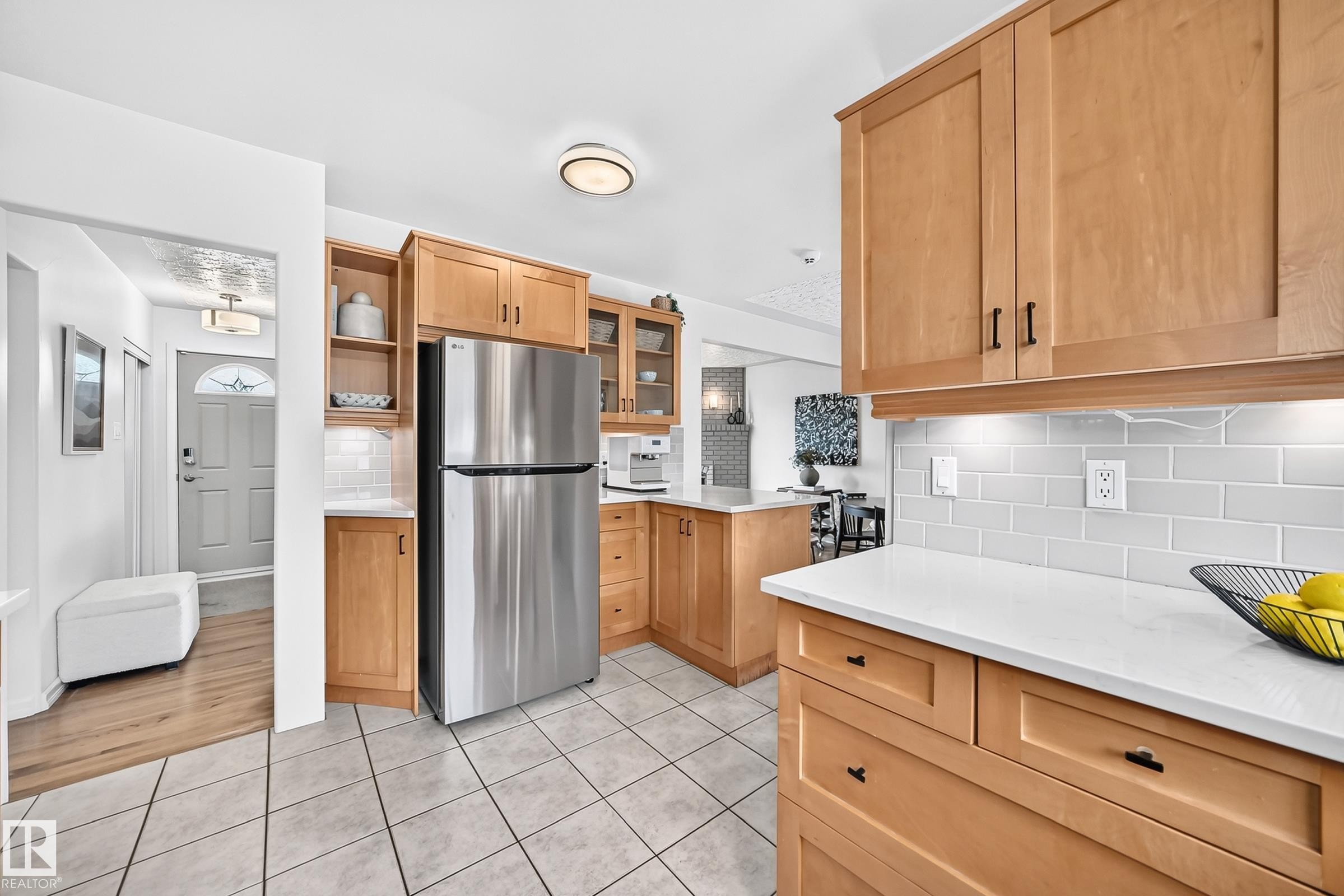 Kitchen featuring wood-finish cabinetry, white countertops, tile flooring, and a subway tile backsplash - 16406 87A Avenue Nw, Edmonton, AB - Indoor Photo Showing Kitchen