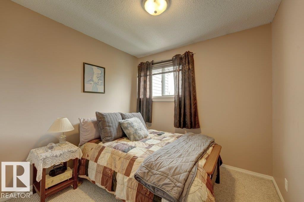 Carpeted flooring, neutral wall color, window with horizontal blinds, built-in ceiling light fixture - 307 Northgate Terrace Nw, Edmonton, AB - Indoor Photo Showing Bedroom