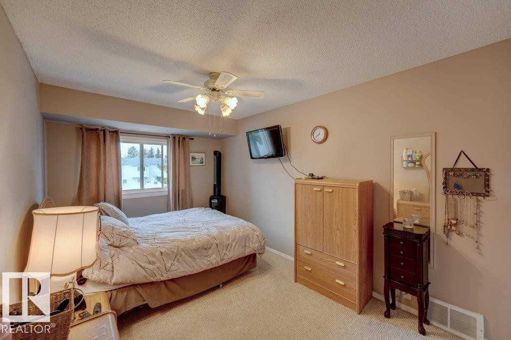 Recessed window with drapes, wall-mounted television, and ceiling fan with light fixture - 307 Northgate Terrace Nw, Edmonton, AB - Indoor Photo Showing Bedroom