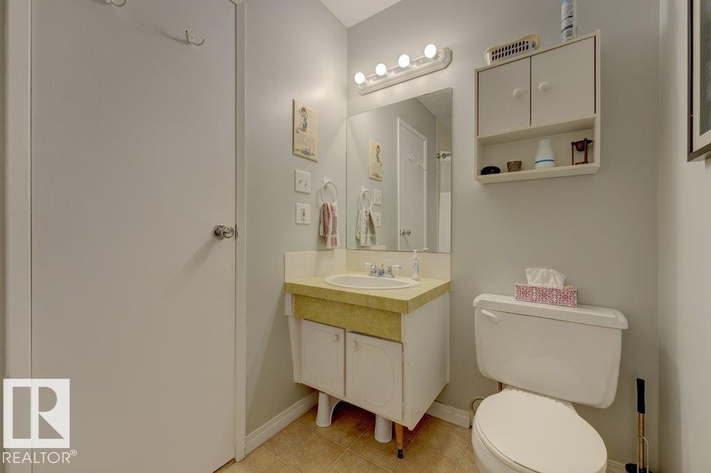 Vanity with integrated sink, mounted mirror, overhead lighting, and wall-mounted storage cabinet - 307 Northgate Terrace Nw, Edmonton, AB - Indoor Photo Showing Bathroom