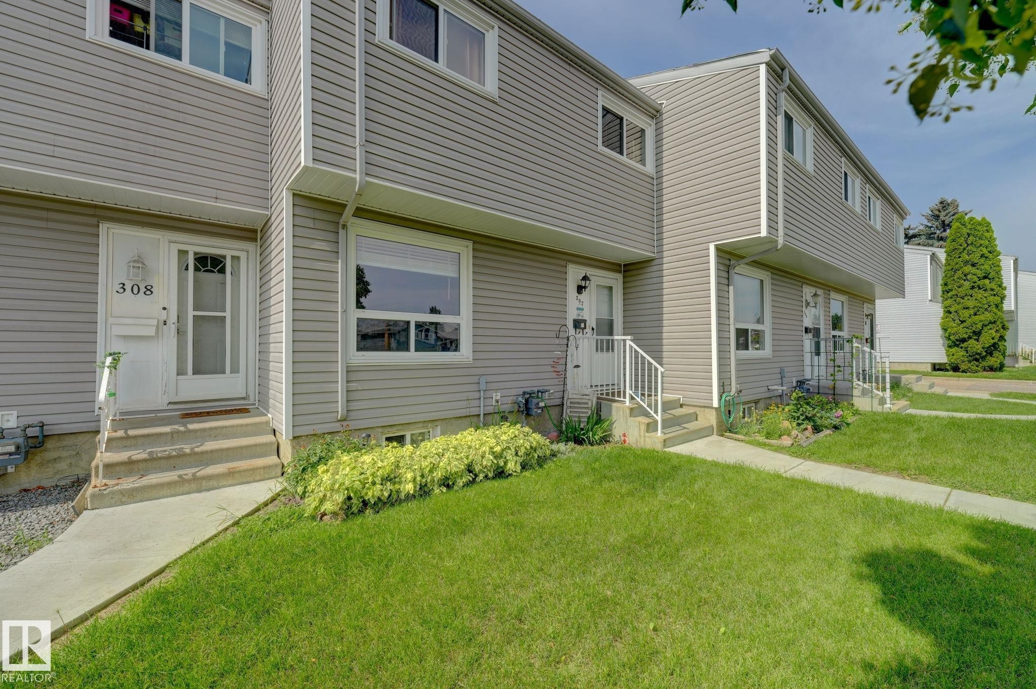 Townhouse exterior featuring gray siding, white trim, and a concrete walkway - 307 Northgate Terrace Nw, Edmonton, AB - Outdoor