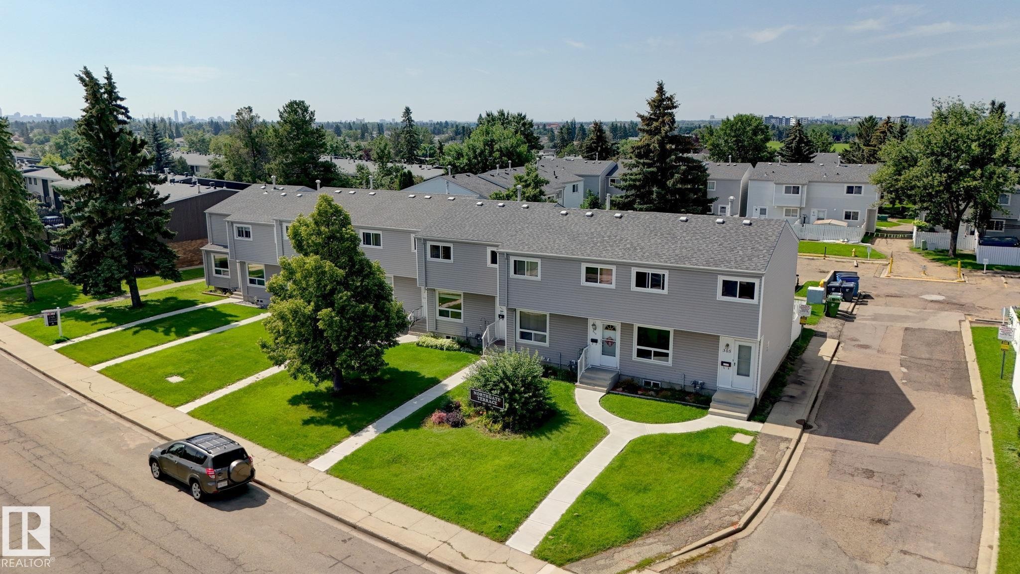 Townhouse-style residences featuring grey siding, white trim, and individual front entrances - 307 Northgate Terrace Nw, Edmonton, AB - Outdoor