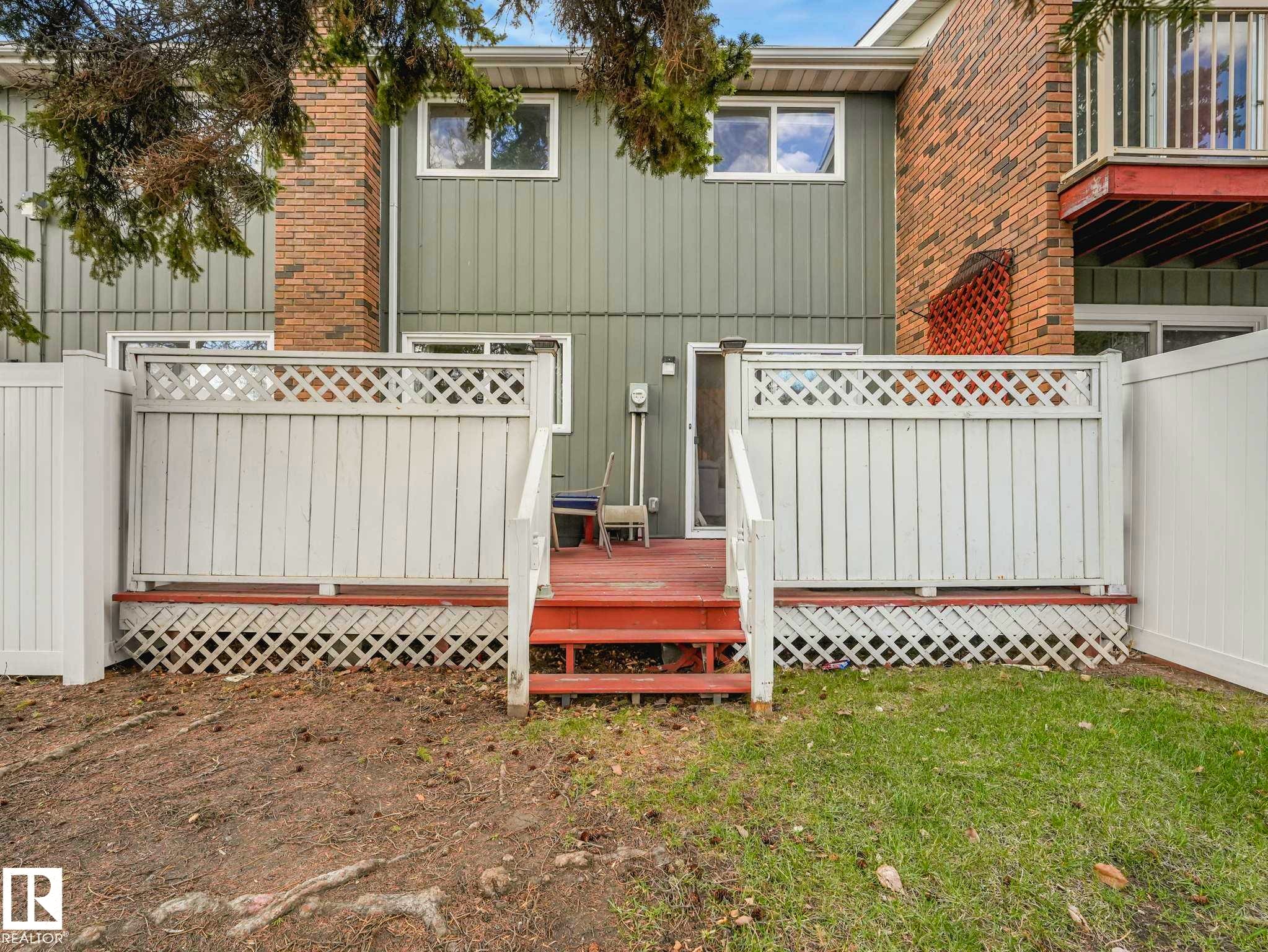 Private deck with white lattice fencing, featuring steps to a partially landscaped yard - 13405 40 St Nw, Edmonton, AB - Outdoor With Exterior