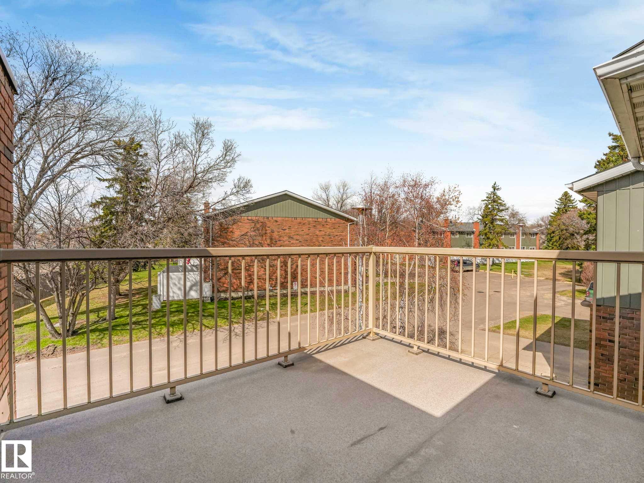 Private balcony with a light-colored railing and a gray concrete surface - 13405 40 St Nw, Edmonton, AB - Outdoor With Balcony