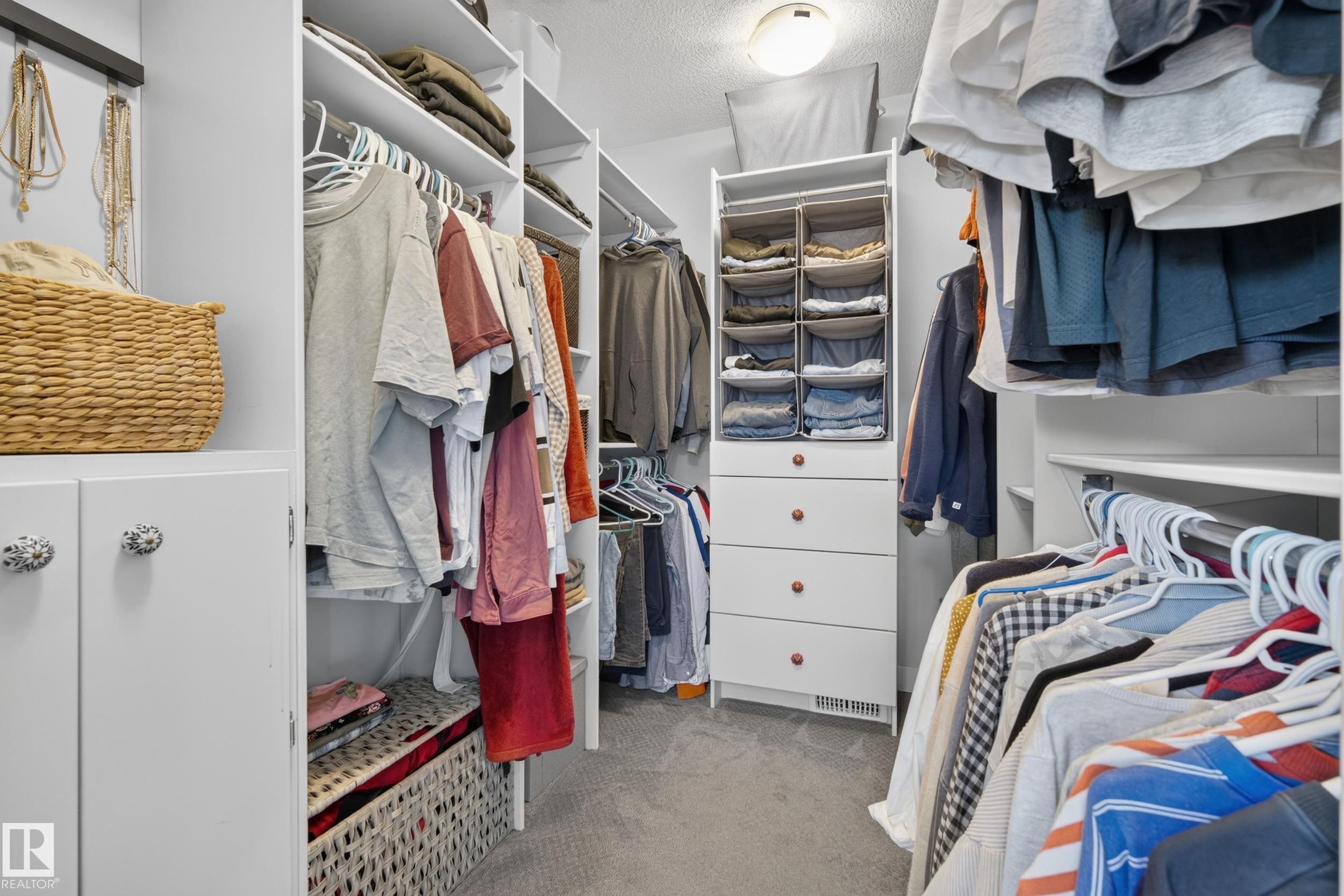 Custom closet system featuring built-in shelving, hanging rods, and a four-drawer storage unit - 11018 122 Street Nw, Edmonton, AB - Indoor With Storage