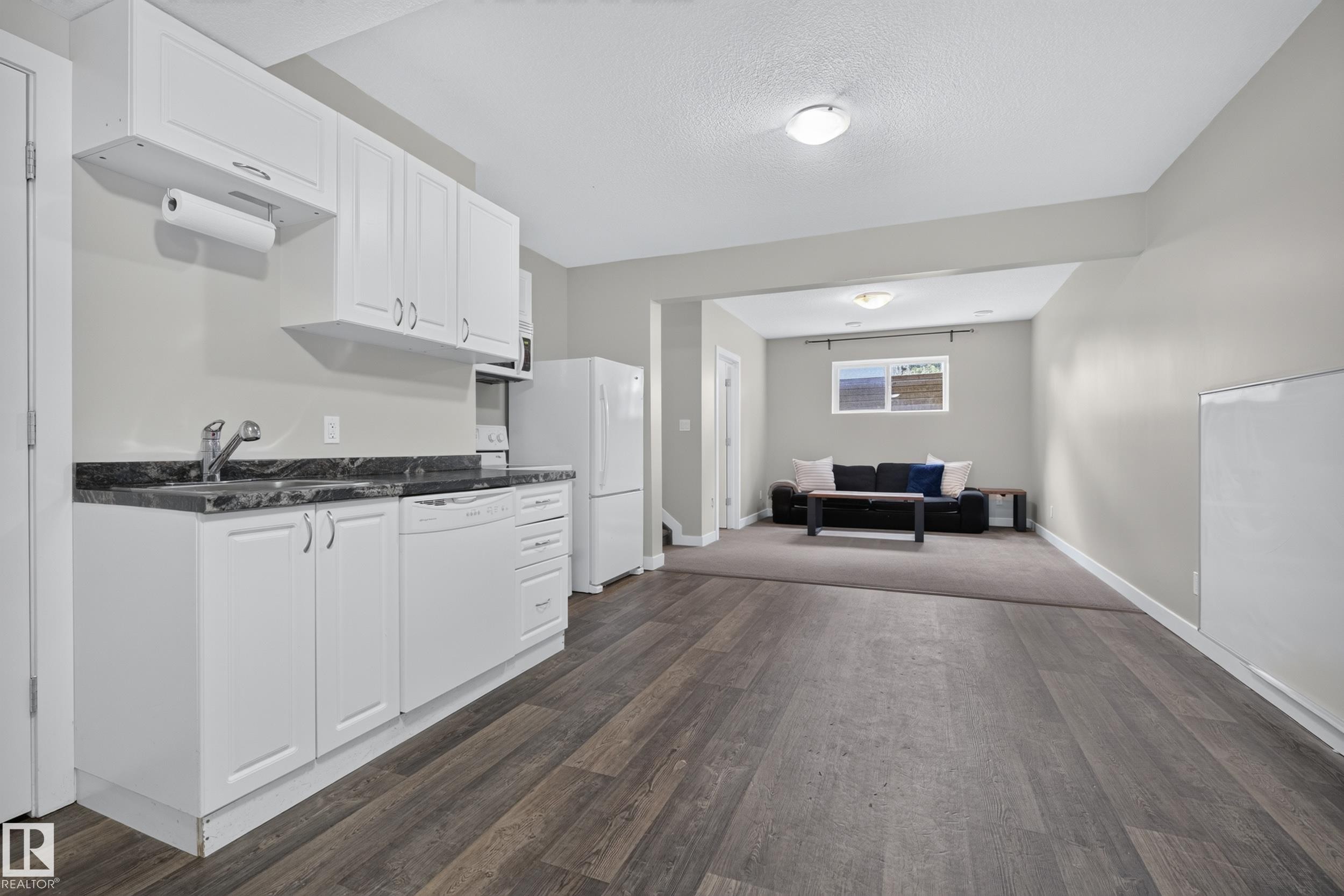 White cabinetry with a dark countertop and stainless steel sink - 11018 122 Street Nw, Edmonton, AB - Indoor Photo Showing Kitchen