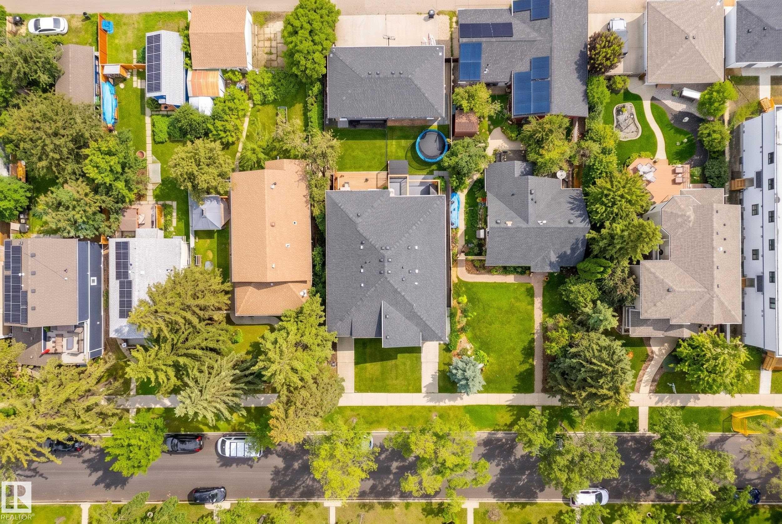 Aerial perspective showcasing a residential neighborhood with mature trees, green lawns, asphalt streets, and sidewalks - 11018 122 Street Nw, Edmonton, AB - Outdoor With View
