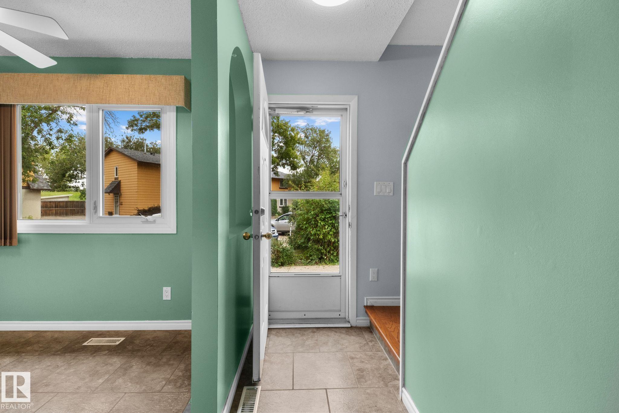 White-framed window, tile flooring, and light-toned wall finishes - 152 Woodstock Nw, Edmonton, AB - Indoor Photo Showing Other Room