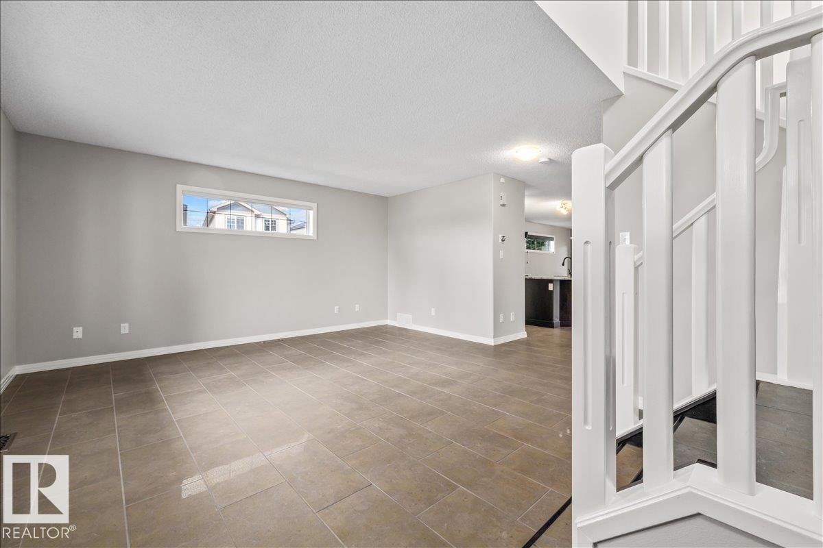 Open-concept living area with neutral gray walls and large format tile flooring - 1086 Grantham Drive Nw, Edmonton, AB - Indoor Photo Showing Other Room