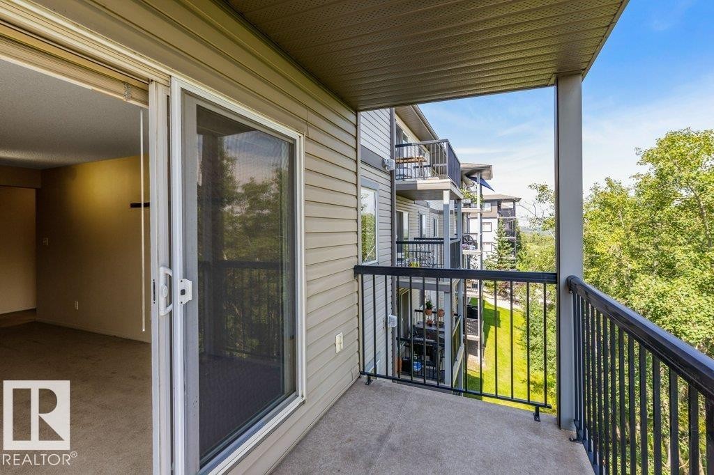 Private balcony with concrete flooring, metal railings, and a sliding glass door - #307 1188 Hyndman Rd Nw, Edmonton, AB - Outdoor With Balcony With Exterior