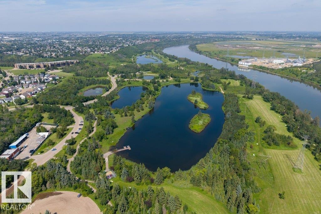 Expansive natural landscape featuring multiple lakes, abundant mature trees, and a winding river - #307 1188 Hyndman Rd Nw, Edmonton, AB - Outdoor With Body Of Water With View
