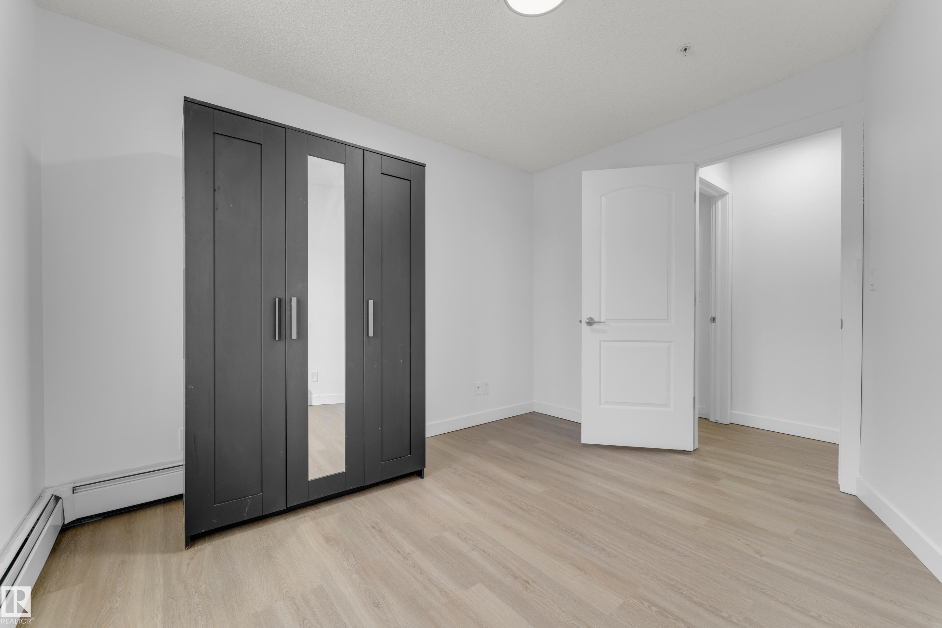 Light wood-finish flooring with white walls - #217 667 Watt Bv Sw, Edmonton, AB - Indoor Photo Showing Other Room