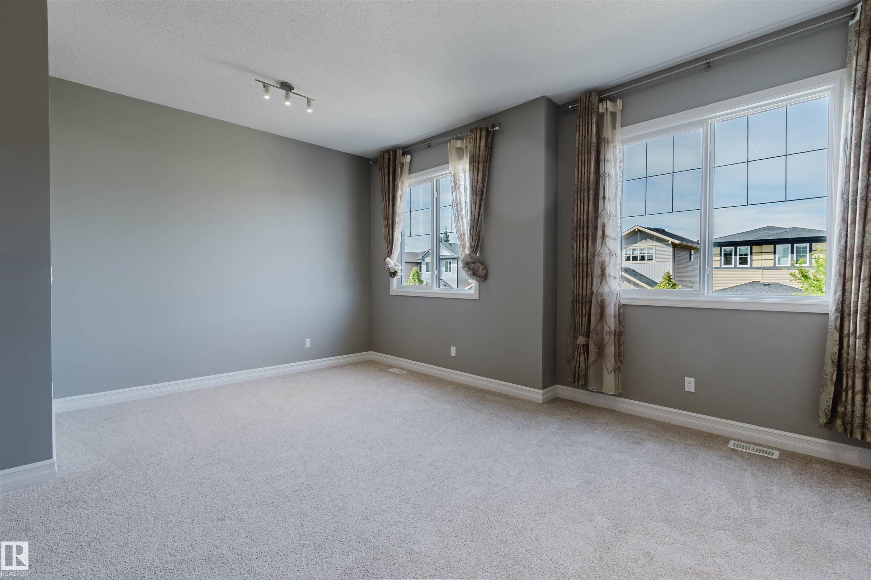 Carpeted flooring with white trim and a neutral color palette - 15839 10 Avenue Sw, Edmonton, AB - Indoor Photo Showing Other Room