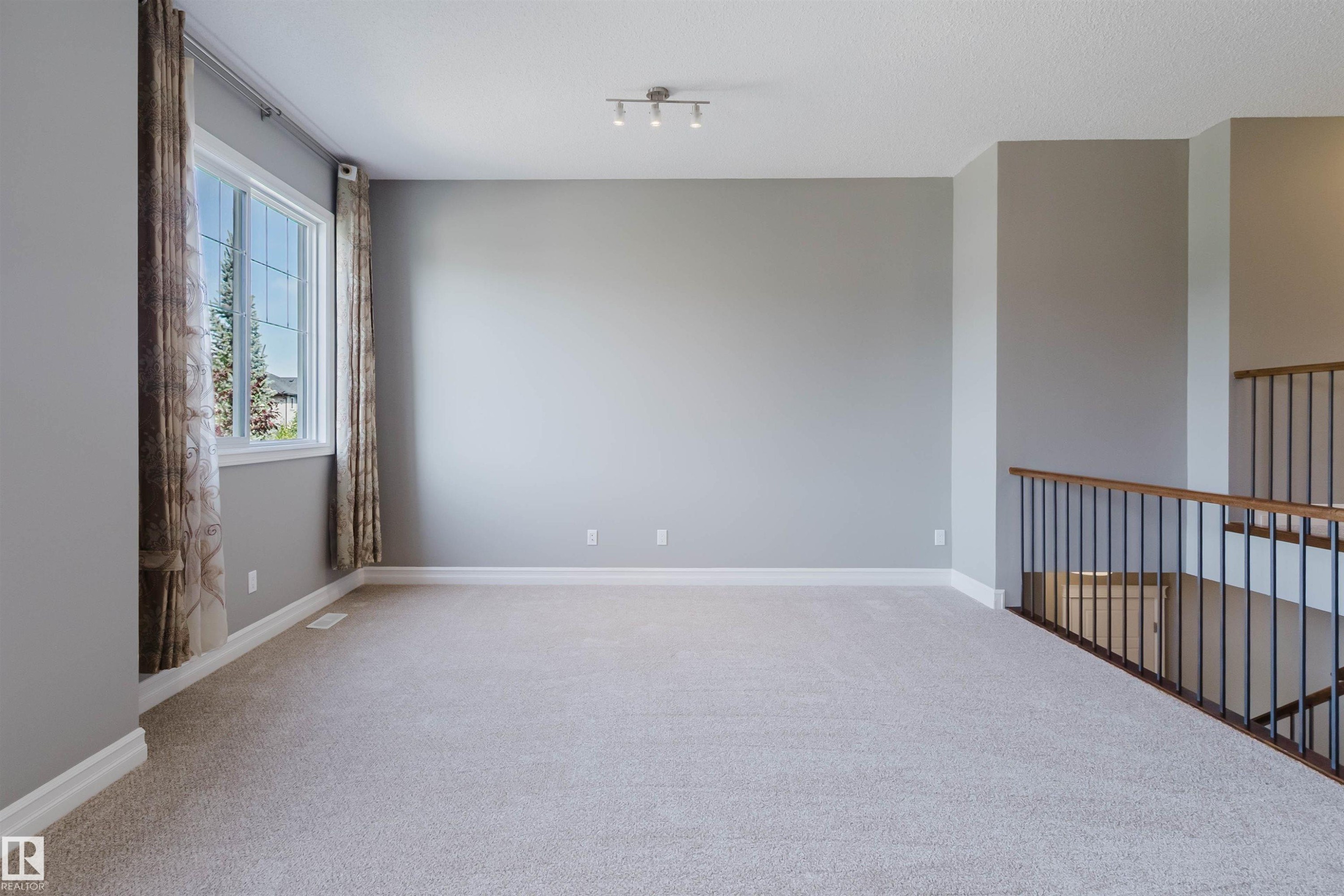 Spacious room with light-toned carpeting and neutral wall tones - 15839 10 Avenue Sw, Edmonton, AB - Indoor Photo Showing Other Room