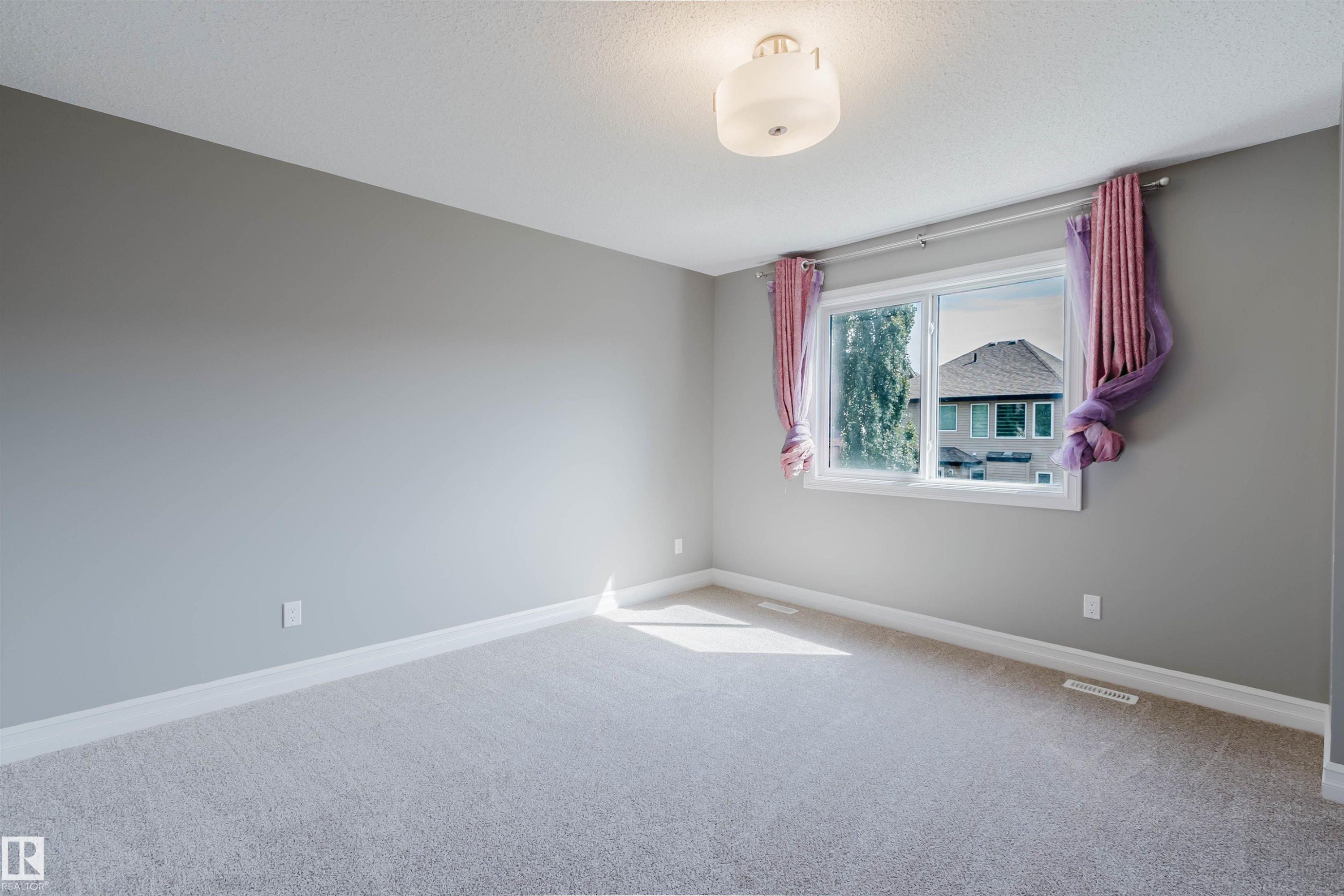 Light gray wall paint, light-colored carpet, white trim, and a ceiling-mounted light fixture - 15839 10 Avenue Sw, Edmonton, AB - Indoor Photo Showing Other Room