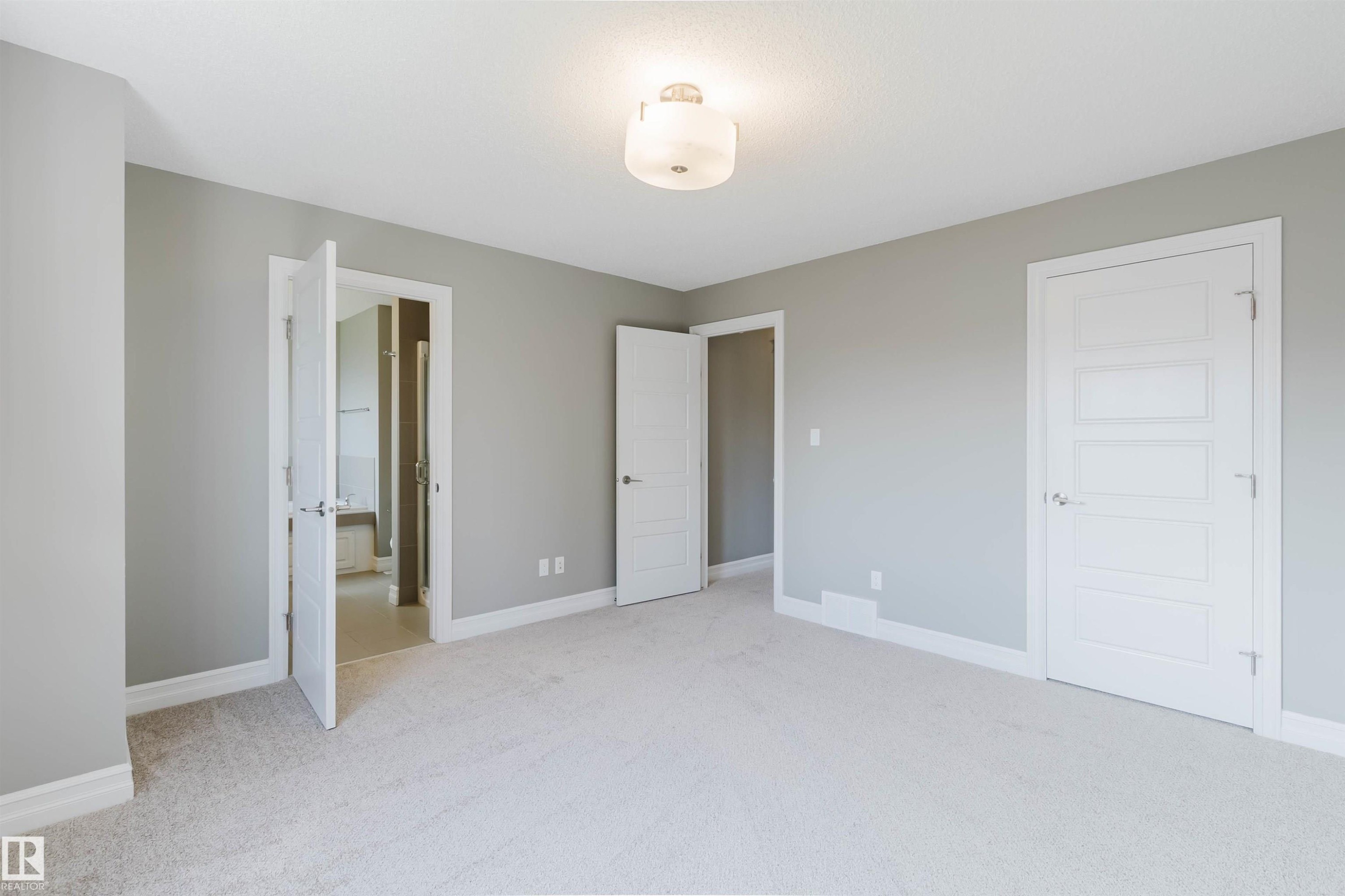 Neutral painted walls, light-colored carpet, white trim, white paneled doors, and an overhead flush mount light fixture - 15839 10 Avenue Sw, Edmonton, AB - Indoor